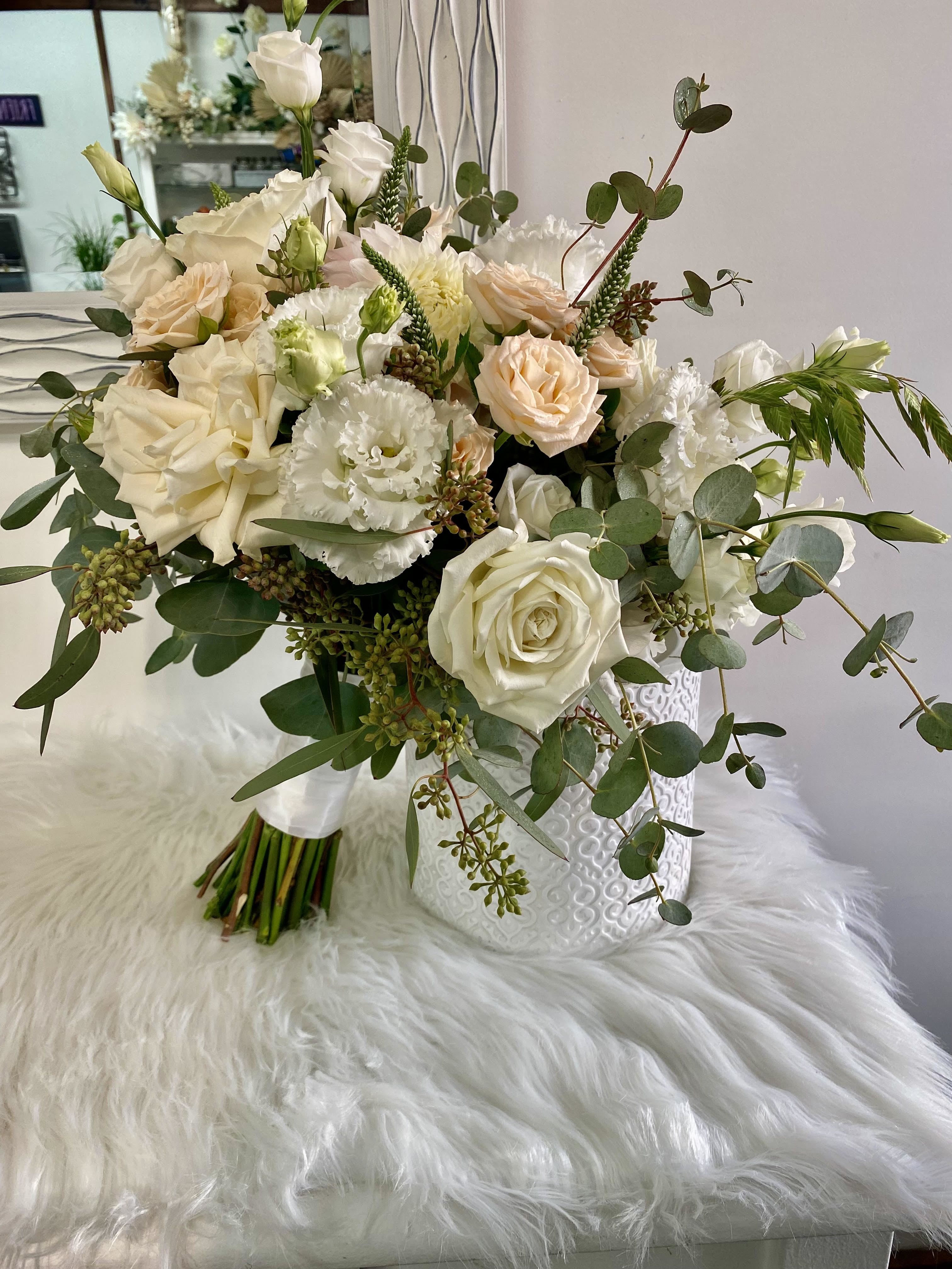 White and blush rose bouquet with eucalyptus in a white vase