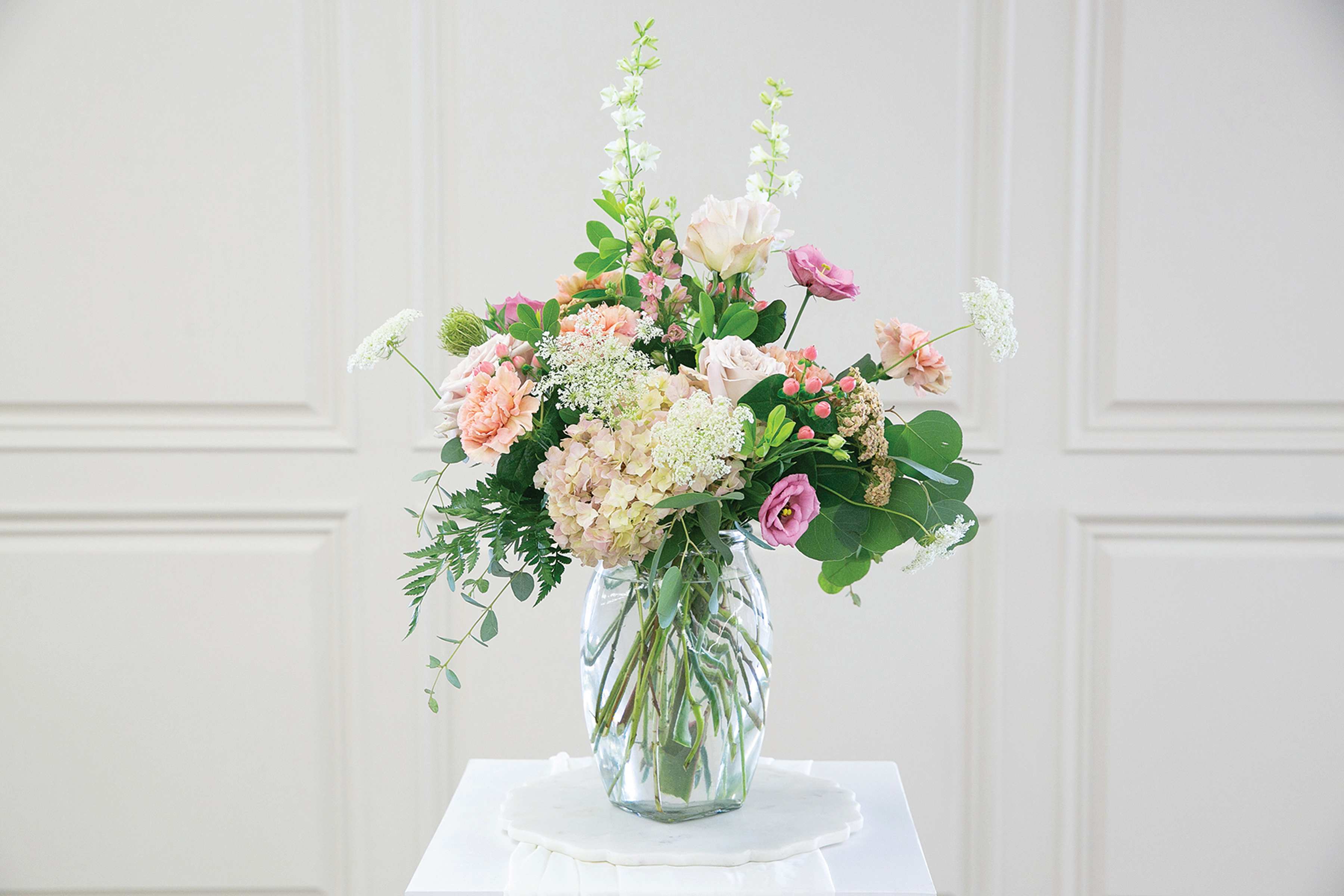 Pastel mixed flower arrangement in a clear glass vase