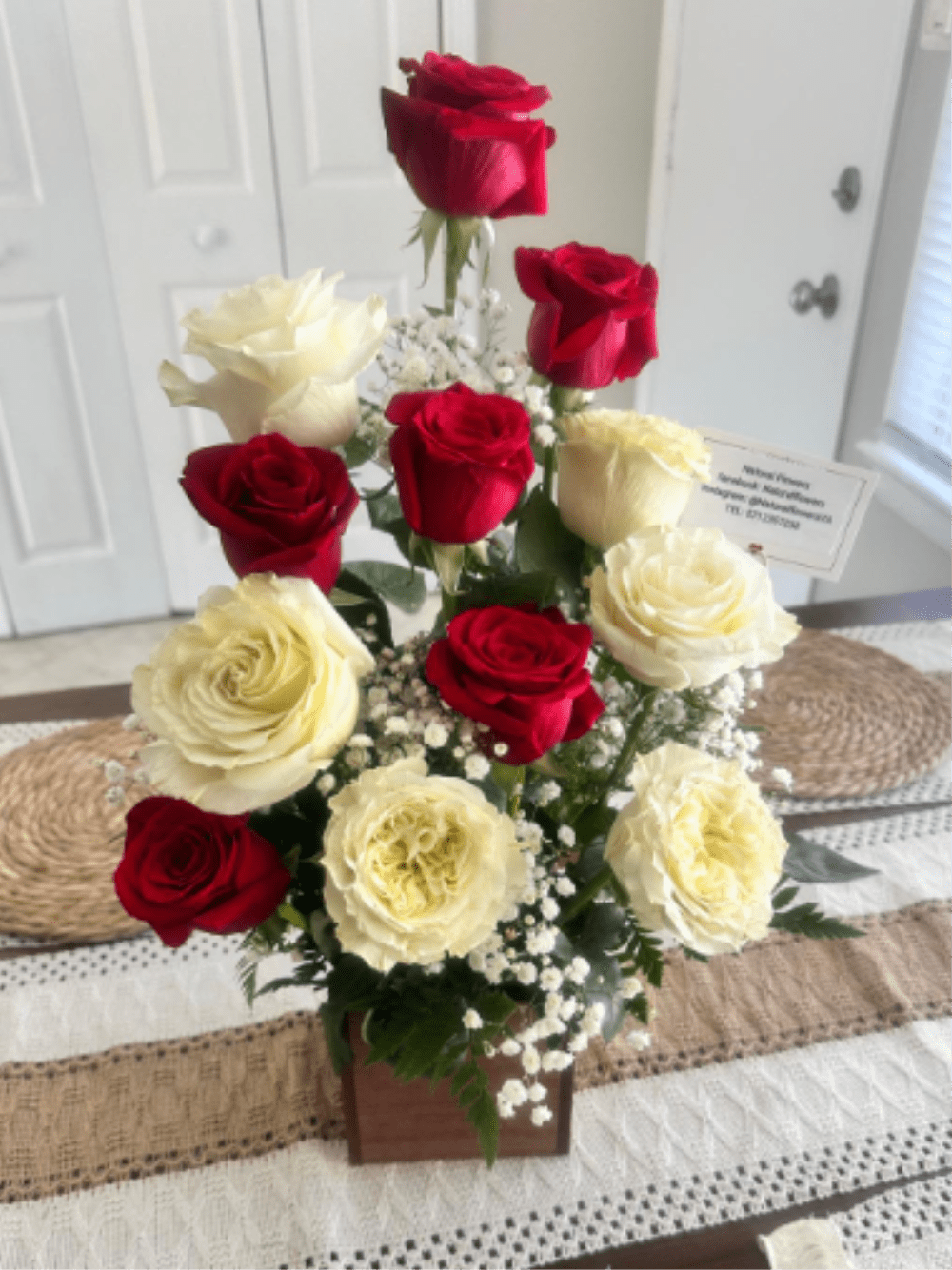 Velvet and Ivory - This exclusive floral design stands out for the harmonious contrast between deep crimson red and the ivory white of its garden roses—varieties known for their generous bloom and multiple layers of petals. Accompanied by delicate touches of baby's breath that add a light, airy texture, this arrangement is the perfect choice for those seeking a romantic gesture with a rustic yet modern flair. It is ideal as a centerpiece, an anniversary gift, a Mother's Day present, or a special accent for the home. Each arrangement is unique and handcrafted; therefore, dimensions may vary slightly.