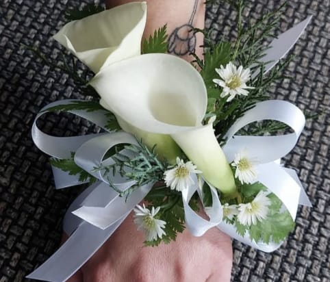 White calla lily wrist corsage with small white daisies and ribbon