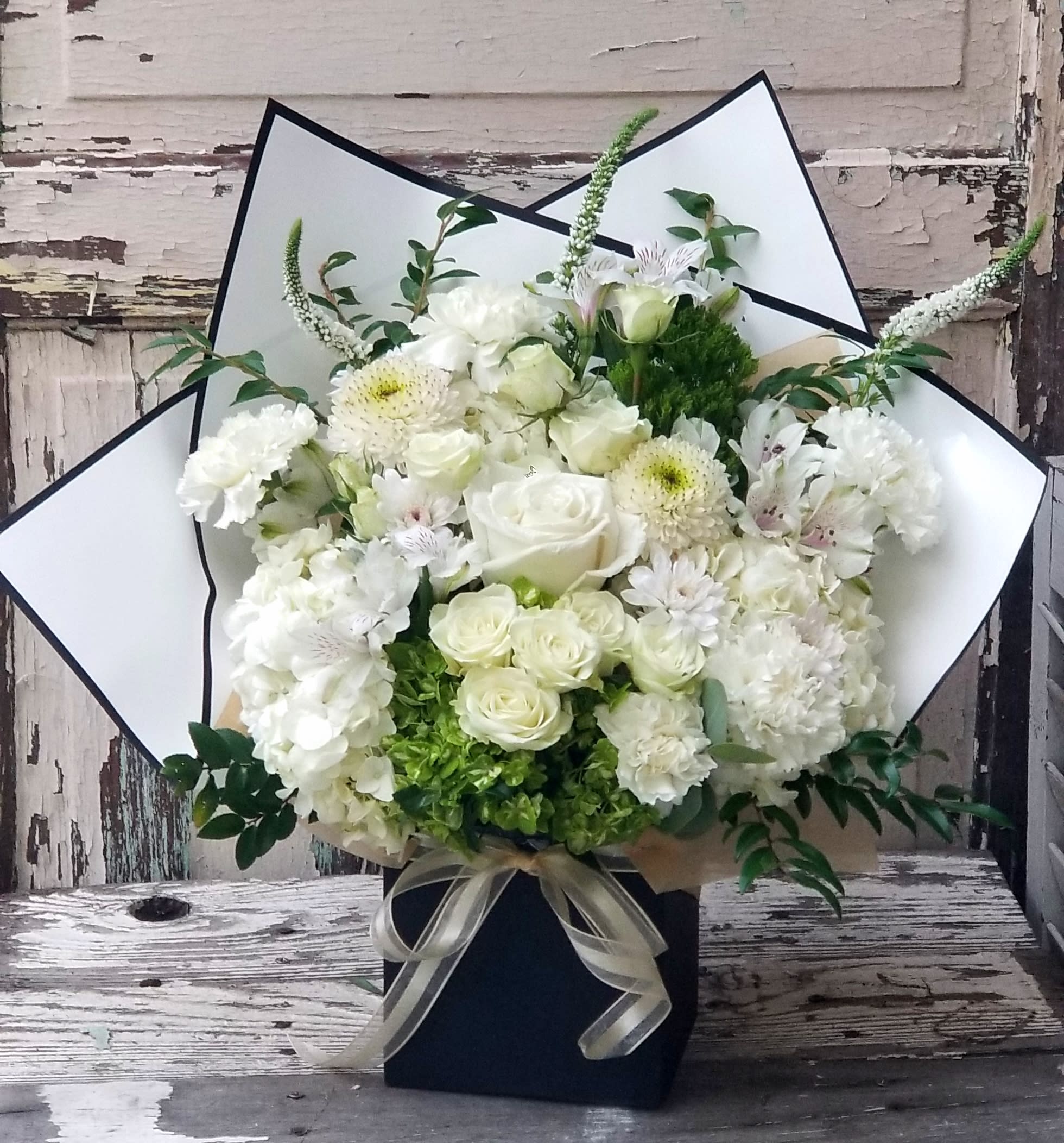 White floral bouquet with roses and chrysanthemums in a black box