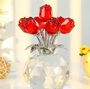 Five red rose-shaped decorative stems in a clear faceted vase