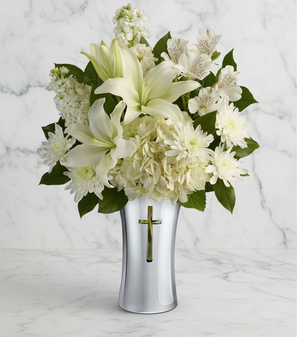 Shining Spirit Bouquet - Show your sympathy with style and grace. A shining silver finish and reverent cross cut-out makes this stunning ceramic vase the perfect accompaniment for a lush bouquet of pure white hydrangea, lilies, alstroemeria and stock.