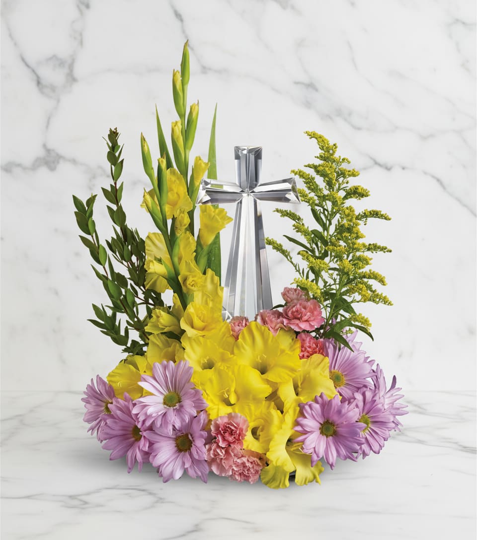 Crystal Cross Bouquet - Celebrate the reason for the season with radiant flowers cradling an exquisitely crafted Crystal Cross. This lovely gift will be a source of inspiration for years to come.  The scale of the arrangement should determine the type of substitution acceptable, but the substitution must be of equal or greater value and must maintain the style and color harmony of the original order.
