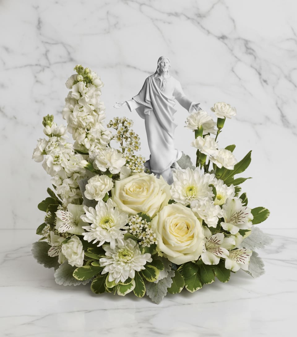 Forever Faithful Bouquet - An elegant display of faith and grace, this beautiful arrangement will comfort the bereaved in a truly thoughtful and respectful way. An exquisite sculpture of Jesus is surrounded by a bed of lovely blossoms. It is sure to be appreciated and always remembered.