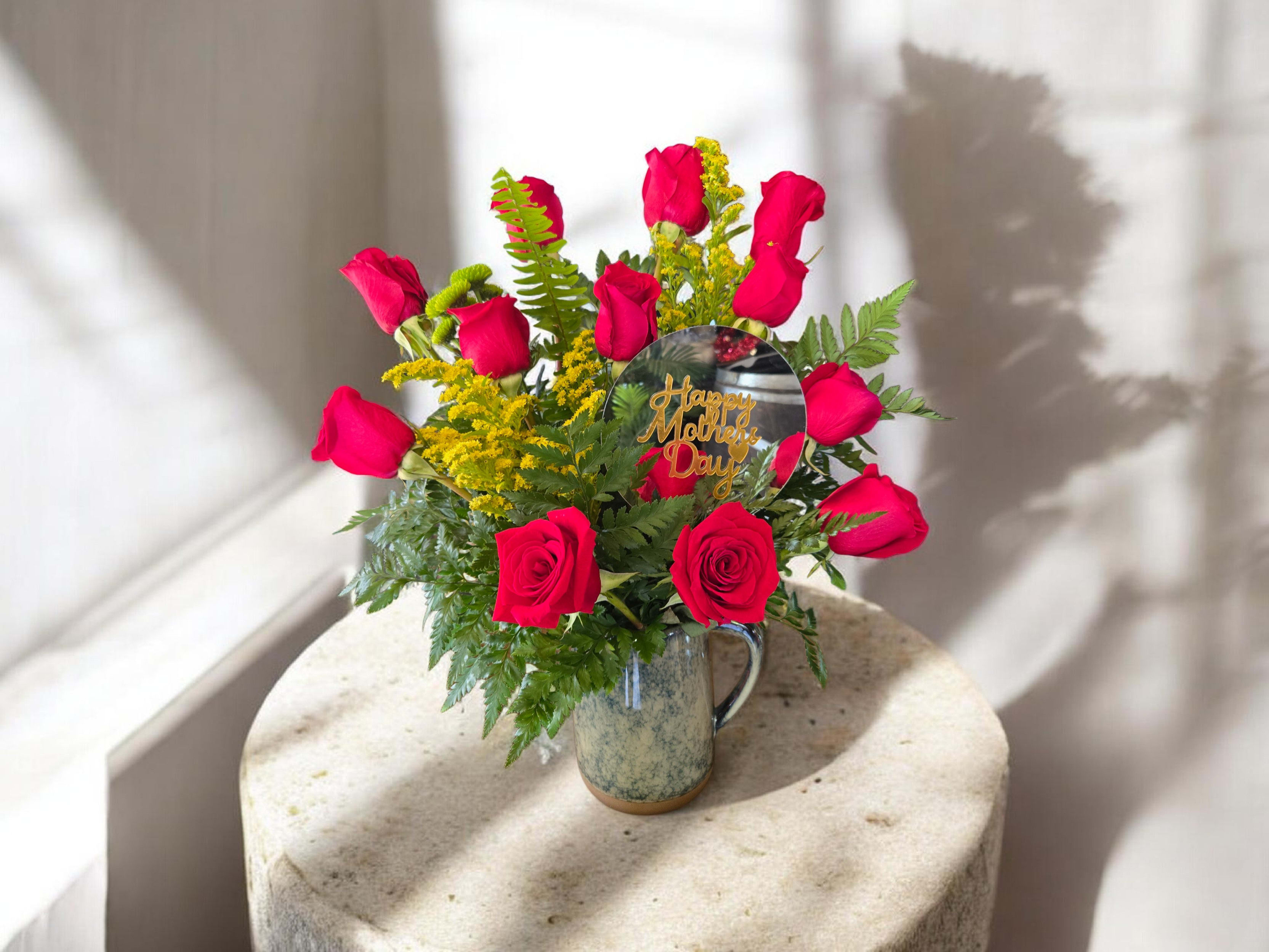 Crimson Garden Arrangement - A striking bouquet of red roses paired with fresh greenery and delicate accent blooms. This elegant arrangement brings warmth and sophistication, making it perfect for romantic gestures or adding a bold touch to any space