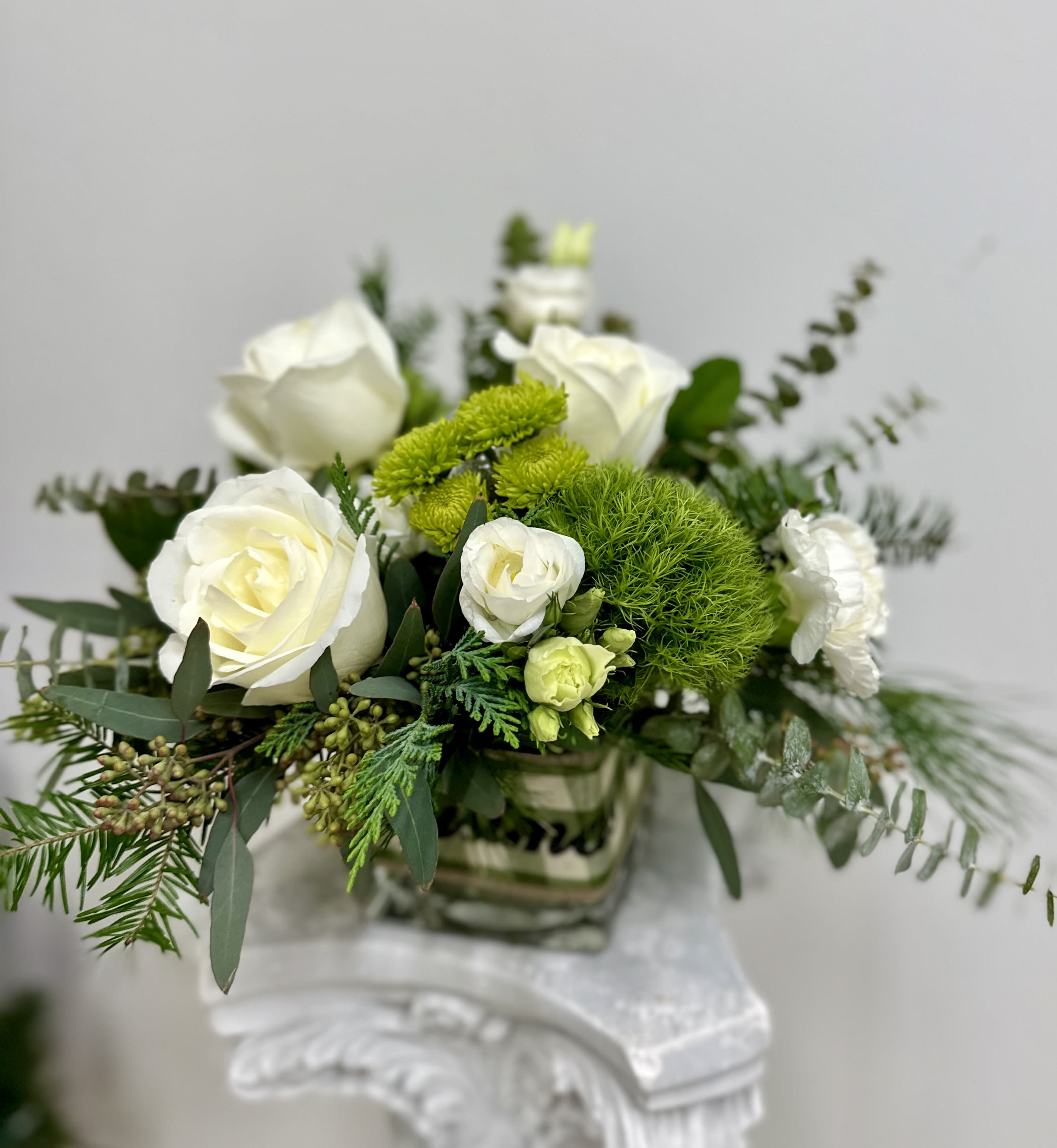 Country Seasonal by Westford Florist Art by Veny - Enhance your space with the timeless charm of Country Seasonal by Westford Florist Art by Veny. This exquisite flower arrangement artfully combines delicate white roses, elegant lisianthus, vibrant green trick, and playful dot poms, all nestled among lush greenery to create a captivating visual experience. Presented in a chic glass vase, this stunning display not only adds sophistication but also transforms any setting into an inviting oasis. Perfect for both professional environments and personal spaces, it’s an ideal choice for those seeking to elevate their decor with effortless style. Make every moment special with this beautiful floral masterpiece.