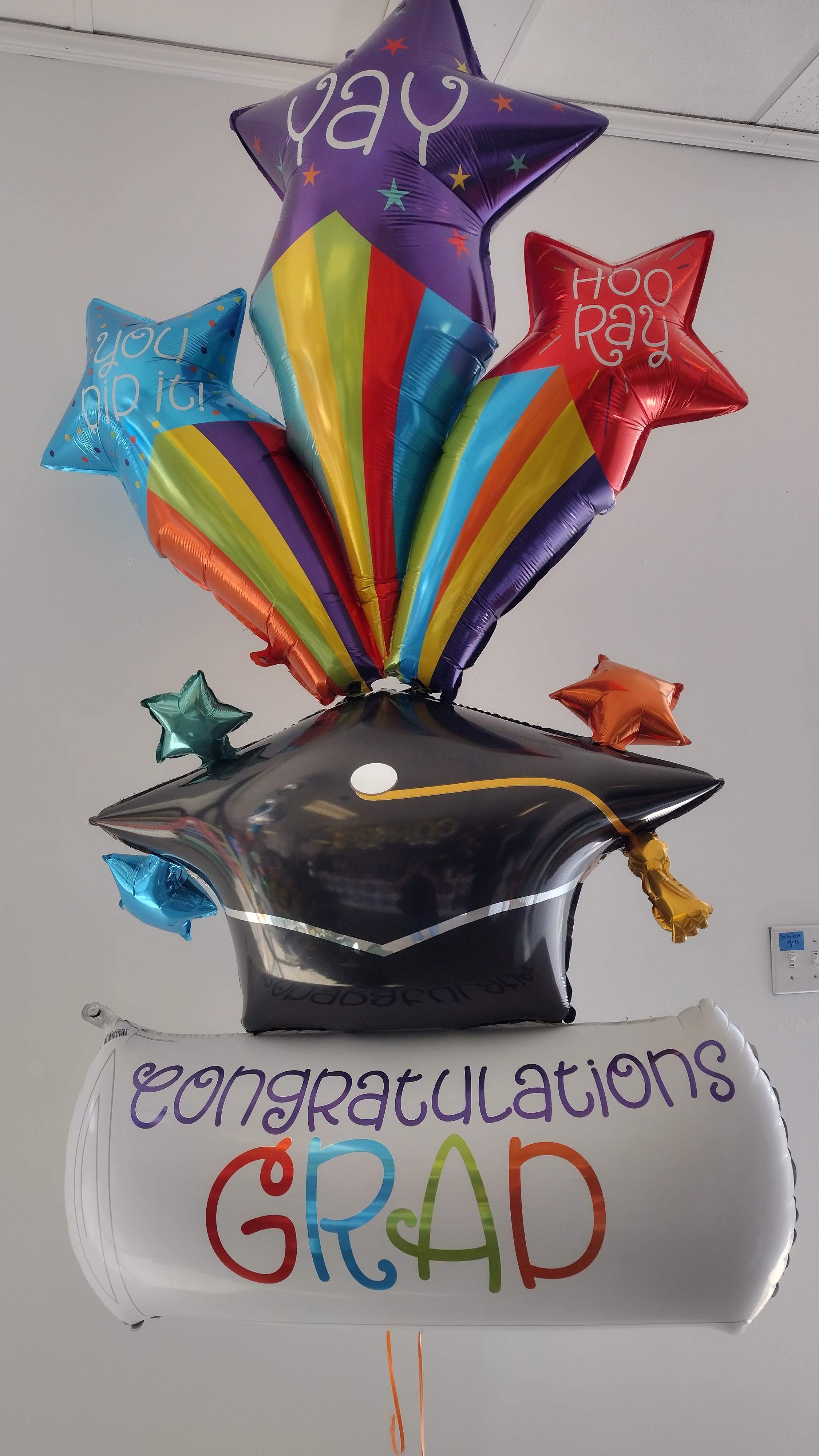 Graduation balloon bouquet with stars and a cap-shaped balloon