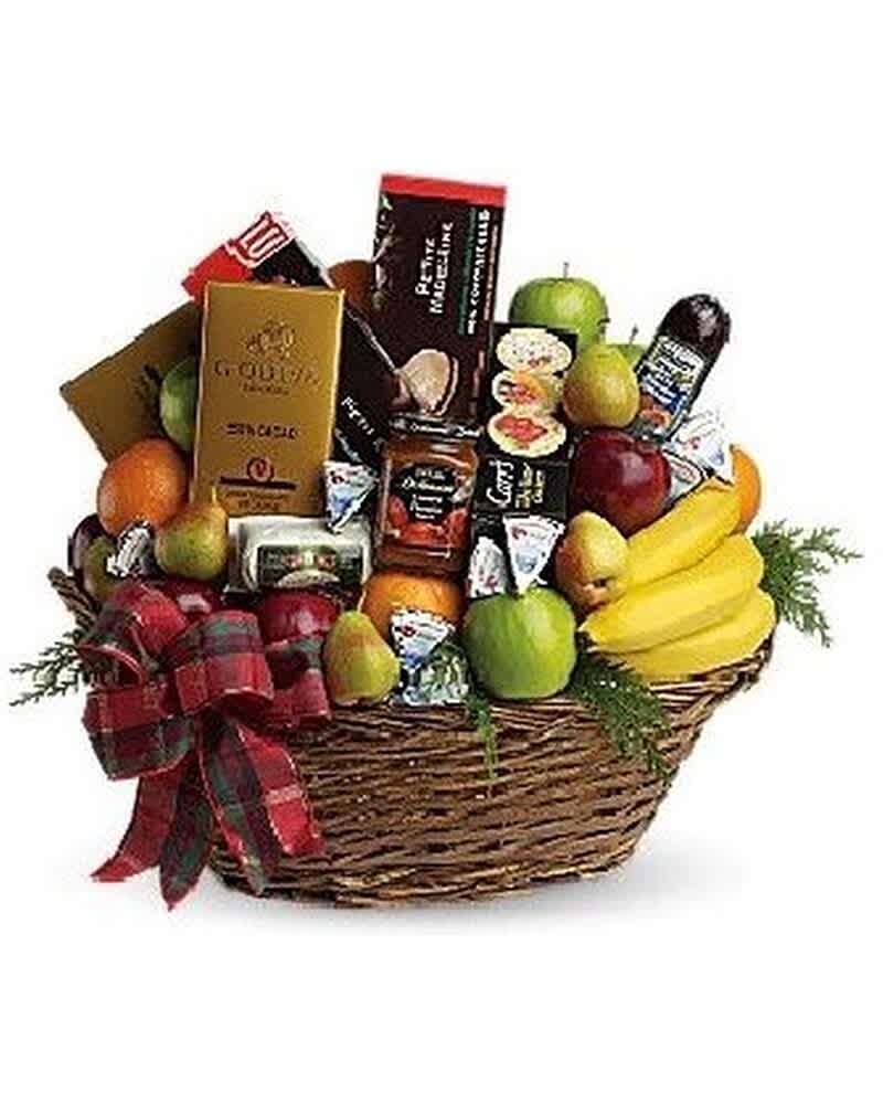 Large wicker gift basket filled with assorted fruits, gourmet snacks, and a plaid ribbon bow
