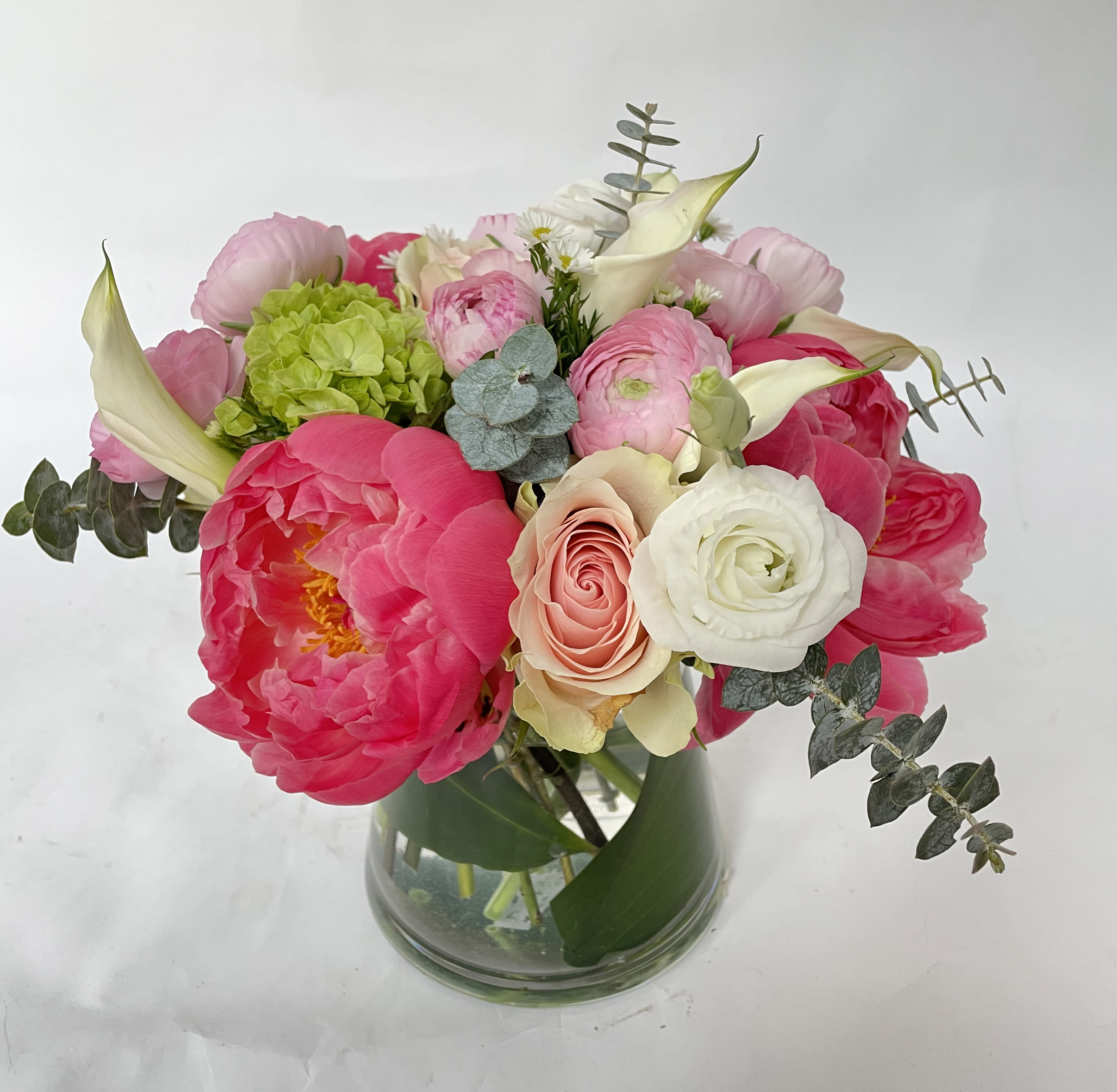 Coral Sunset - This arrangement includes lovely coral peonies, pastel pink roses, pink ranunculus. 