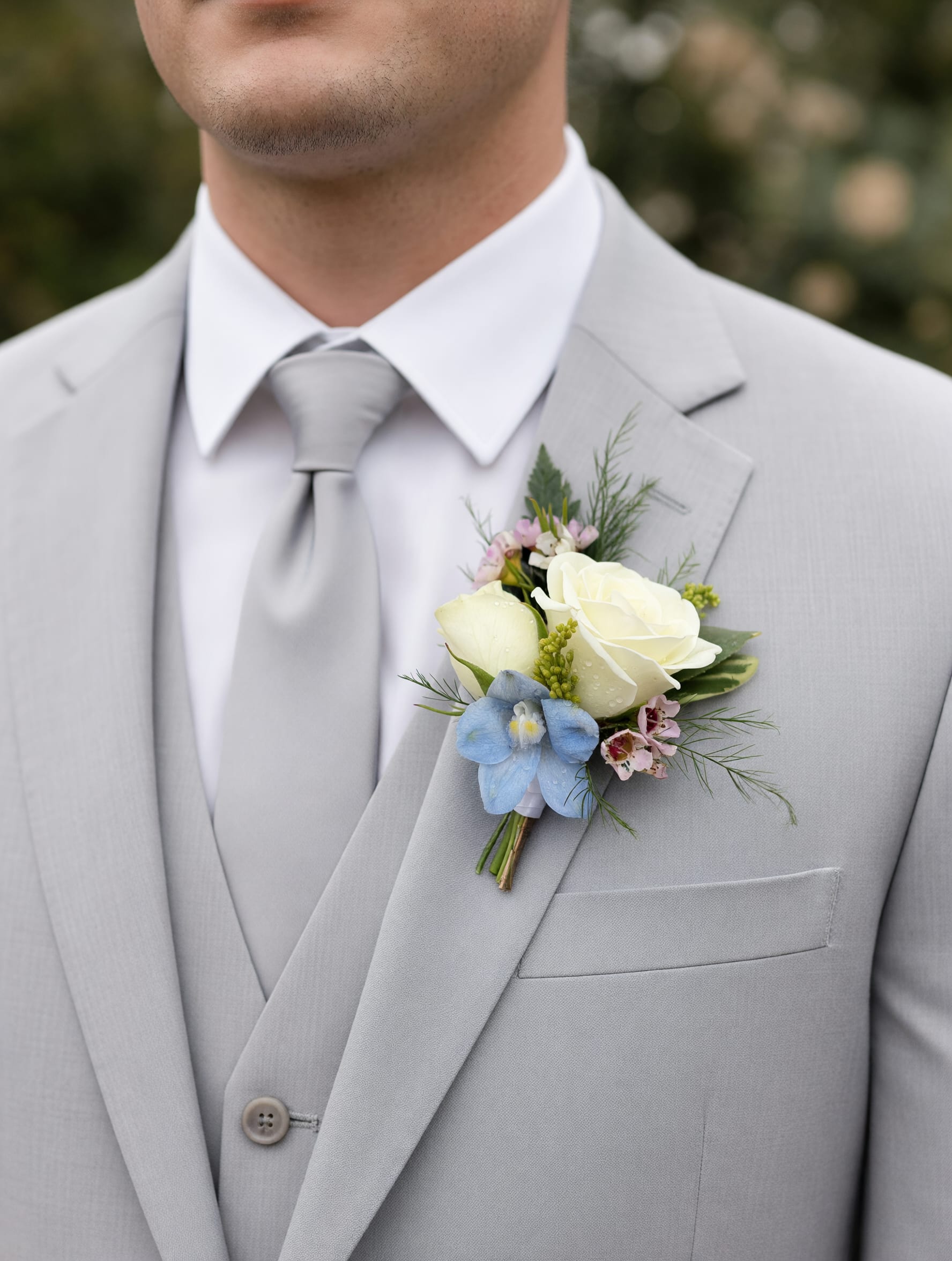 Boutonniere - Pastel Garden - The Pastel Garden Boutonniere consists of primarily white spray roses with soft pastel accents, for a fresh romantic prom look!  Color requests are welcome, but not guaranteed.  Select the deluxe option to order a bout. &amp; corsage set!
