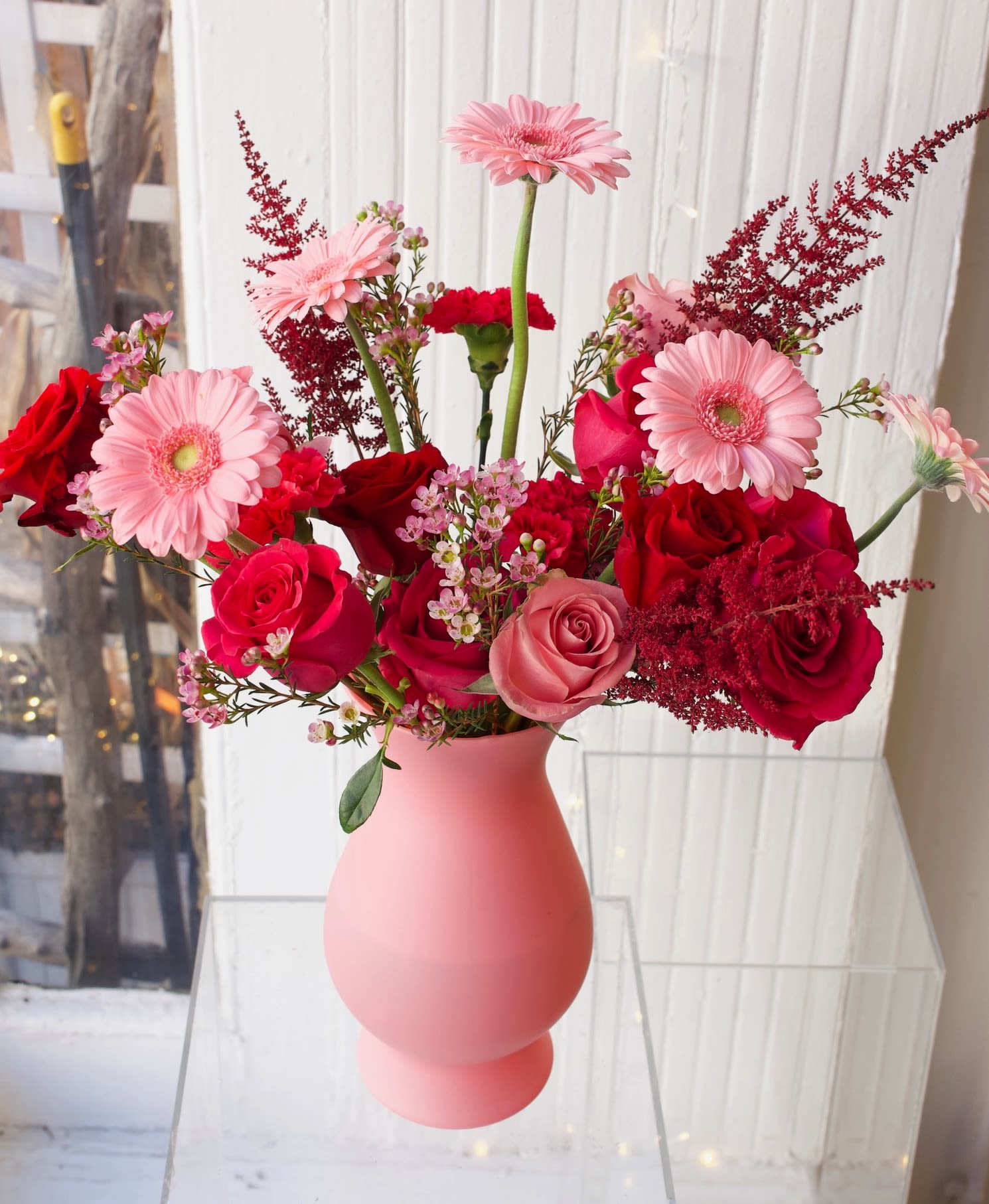 Pink and red mixed bouquet in a matte pink vase