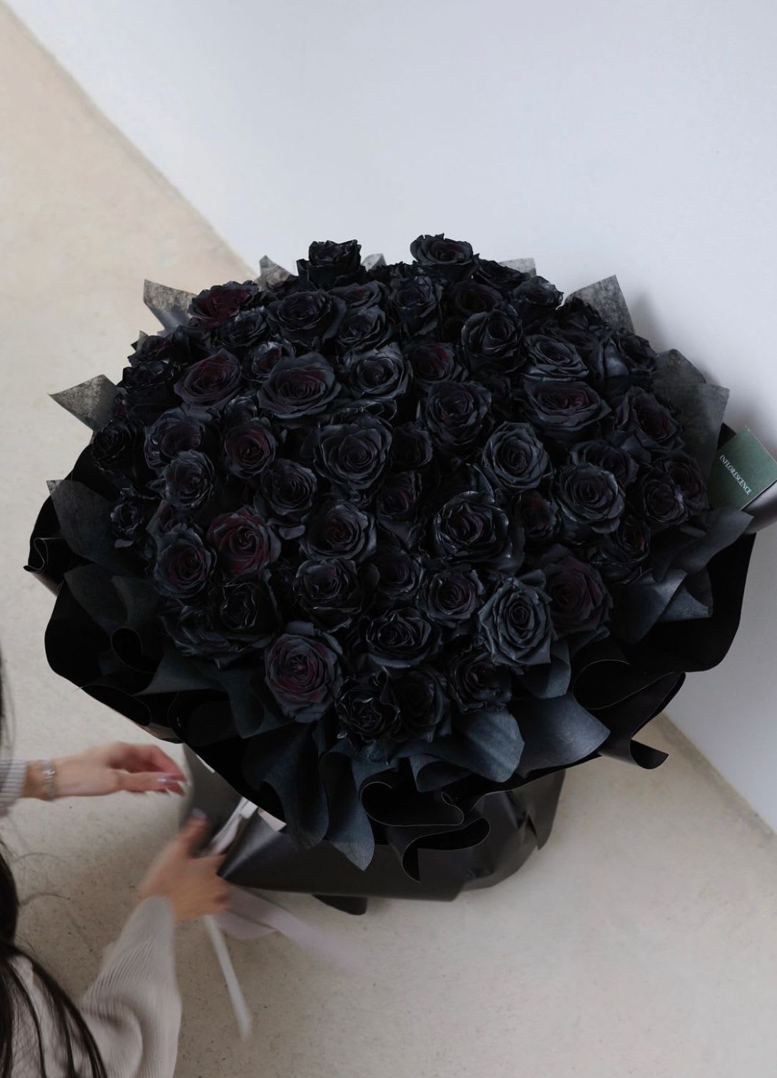 Large bouquet of black roses wrapped in dark paper