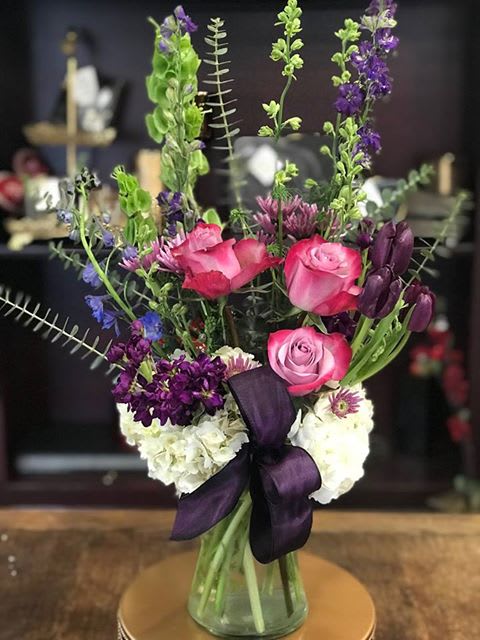 Plum Peace By Flower Carriage  - This bouquet displays the richness of the dark purple.  This arrangement features: roses, tulips, Blue Bella, Bells of Ireland, stock, daisies, hydrangea, Larkspur and eucalyptus.