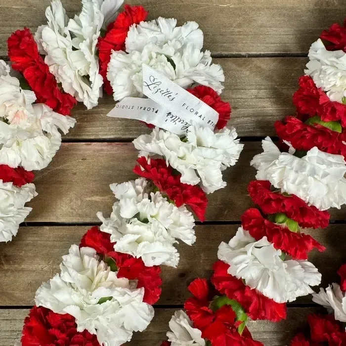 Carnation Leis – Fresh Flower Leis for Celebrations - Celebrate life’s special moments with our handcrafted fresh carnation leis, a timeless symbol of beauty, love, and honor. Designed with vibrant premium carnations, these leis are known for their rich color, delicate fragrance, and lasting freshness—making them ideal for graduations, birthdays, weddings, anniversaries, performances, or cultural celebrations.  Choose from classic colors such as red, white, and antique peach, or customize your lei with school colors or special combinations to make your gift even more personal. Each color carries its own meaning: red carnations symbolize strength and admiration, while white carnations represent purity and versatility.   Advance Ordering Required To ensure the freshest blooms and color availability, please place your order at least 1–2 weeks in advance. For custom color requests, call our studio at SMS: 423-541-2922Call: 423-541-2922423-541-2922.  Care Instructions Keep your lei fresh by storing it in a cool area or refrigerating between 42–55°F until use. With proper care, carnations can last 7–10 days. Do not freeze.  Product ID: Carnation-lei