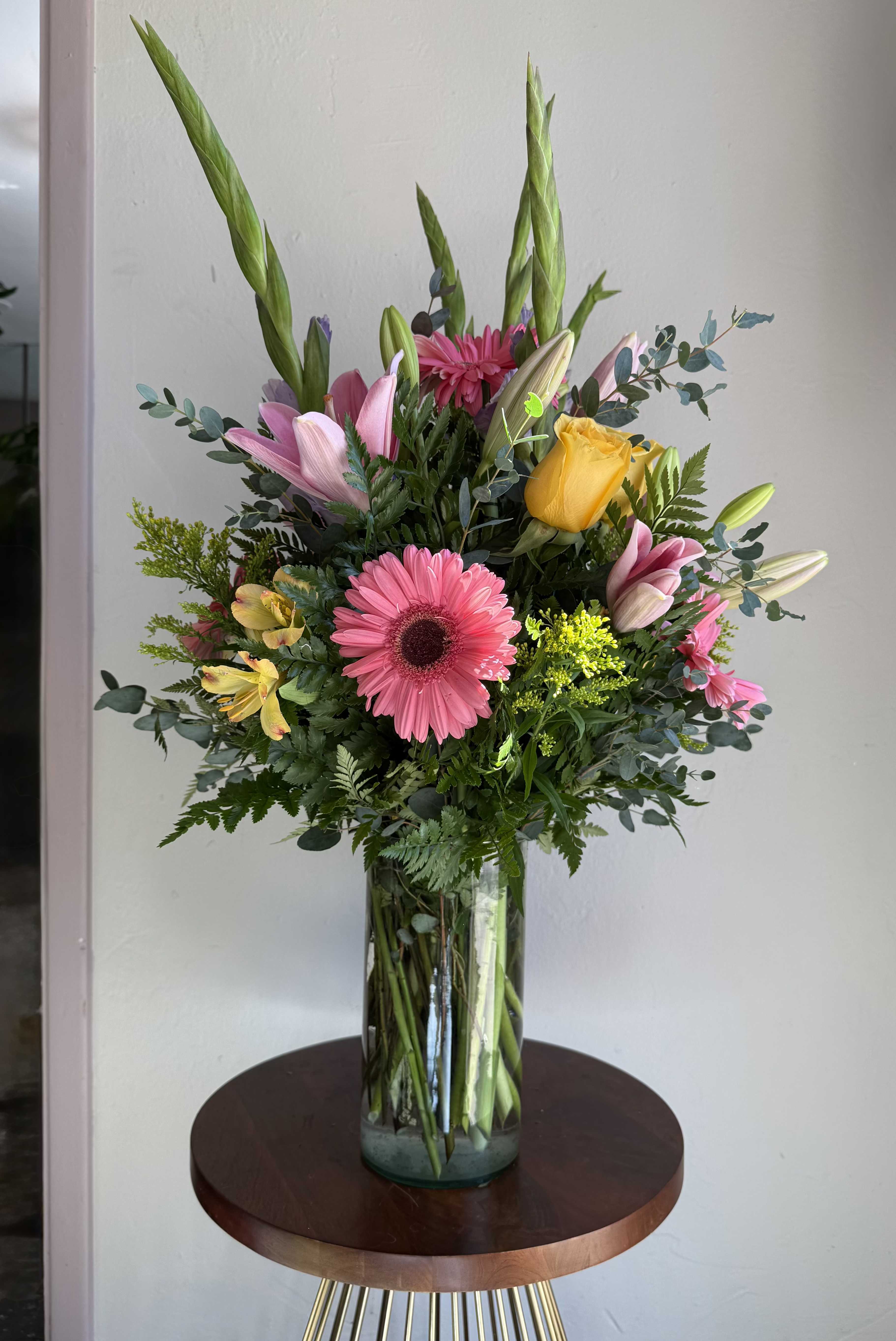 Mixed bouquet in a glass vase with pink, yellow, and white flowers