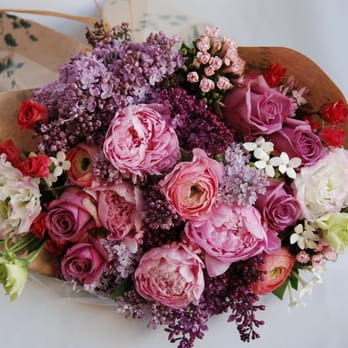 Lilac Wrap Bouquet - Beautiful and Fragrant bouquet of lilacs, lavender roses, pink lisianthus, spray roses, peonies, ranunculus and bouvardia accented with greens and wrapped with craft paper. 