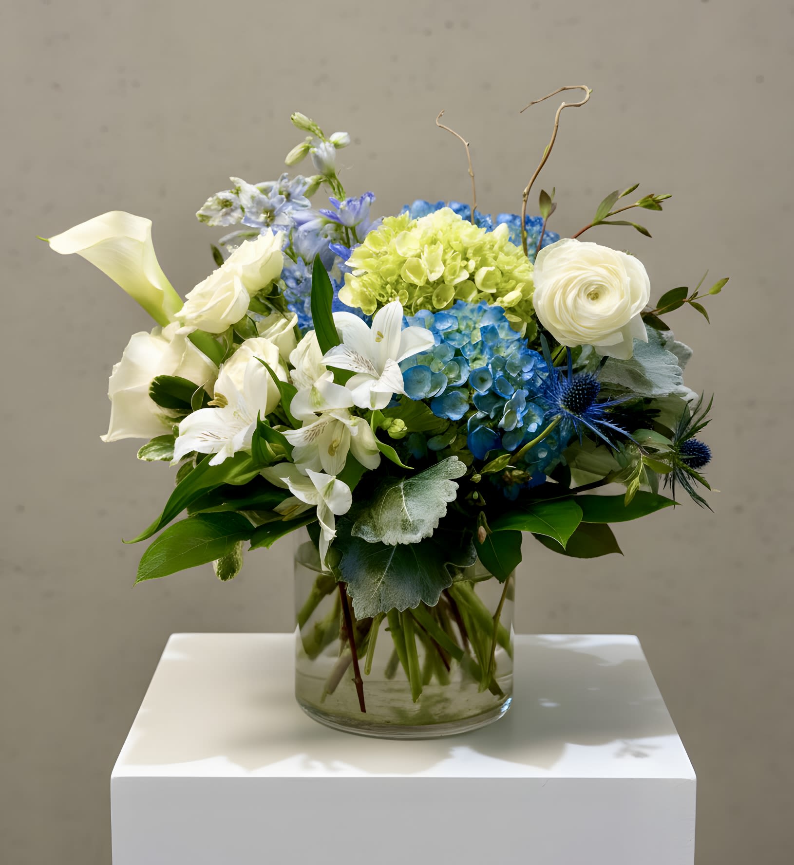 White&amp;Blues - White&amp;Blues is a Stunning Floral arrangement that is sure to make a lasting impression on anyone who sees it. While the specific blooms used may vary depending on availability, the Beauty and Elegance of the arrangement will remain constant, providing a beautiful and uplifting addition to any space.  Please note that specific flower varieties may vary based on availability.  