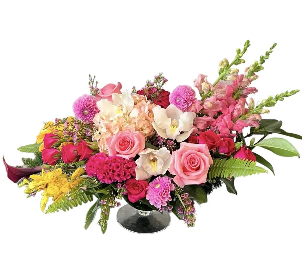 Mixed bouquet of pink, white, and yellow flowers in a glass vase