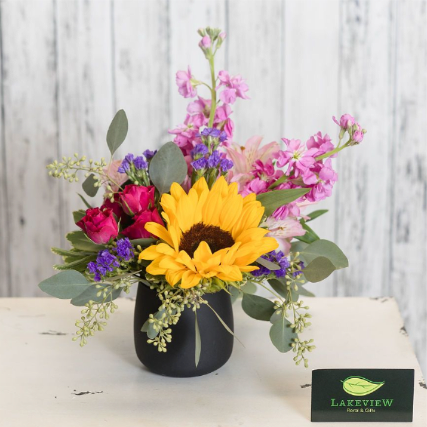 Mixed bouquet with a sunflower in a black vase