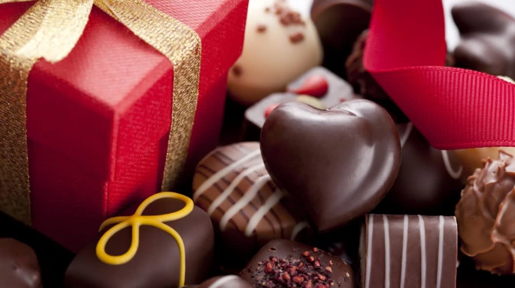 Boxed chocolates with red gift boxes and ribbon