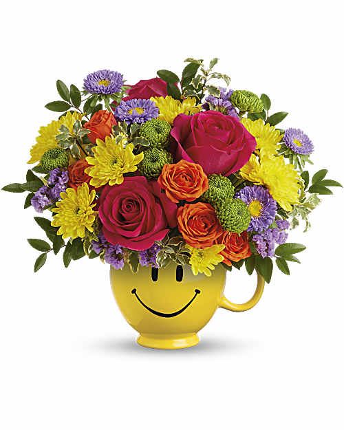Choose Happy Bouquet  - Happiness, delivered! Brighten their day with hot pink roses, orange spray roses, lavender asters, green button and yellow cushion mums, and lavender statice-arranged with huckleberry and pitta negra in a cheerful Be Happy® Mug. It's the perfect gift for mom or a love one! * Arrangement is a Small to Medium Size*