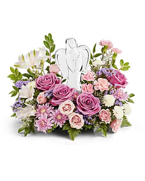 Teleflora's In Heaven's Arms Bouquet - Bring peace and comfort with Teleflora's In Heaven's Arms Bouquet, featuring soothing lavender roses and soft pink blooms surrounding a luminous crystal angel keepsake-an elegant symbol of love's everlasting light. Teleflora's In Heaven's Arms Bouquet includes lavender roses, light pink alstroemeria, pink mini carnations, white button spray chrysanthemums, lavender cushion mums, lavender statice, and limonium. Accented with huckleberry and leatherleaf fern. Presented with a crystal angel keepsake. Orientation: One-Sided