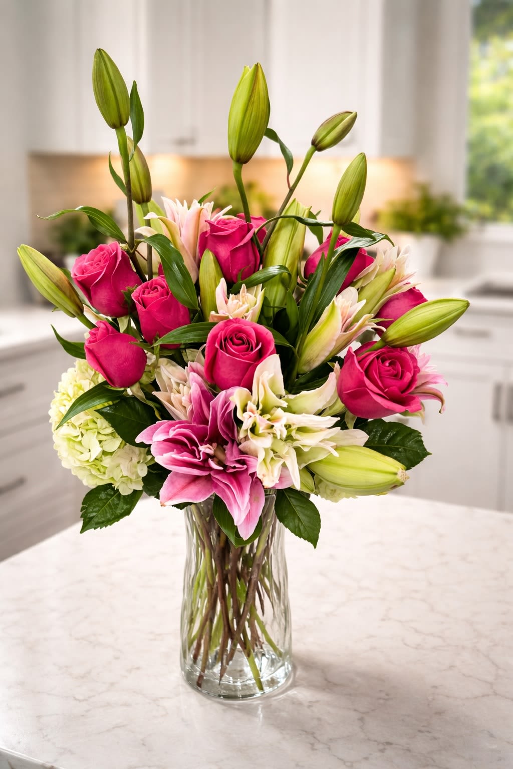 Radiant Lily &amp; Rose Signature - A bold yet refined arrangement featuring vibrant hot pink roses, striking stargazer lilies, and lush hydrangea, accented with fresh greenery and unopened lily buds for extended beauty. Designed with height and movement, this piece brings a modern, upscale feel while still delivering classic romantic charm. Perfect for birthdays, celebrations, or making a statement in any space.