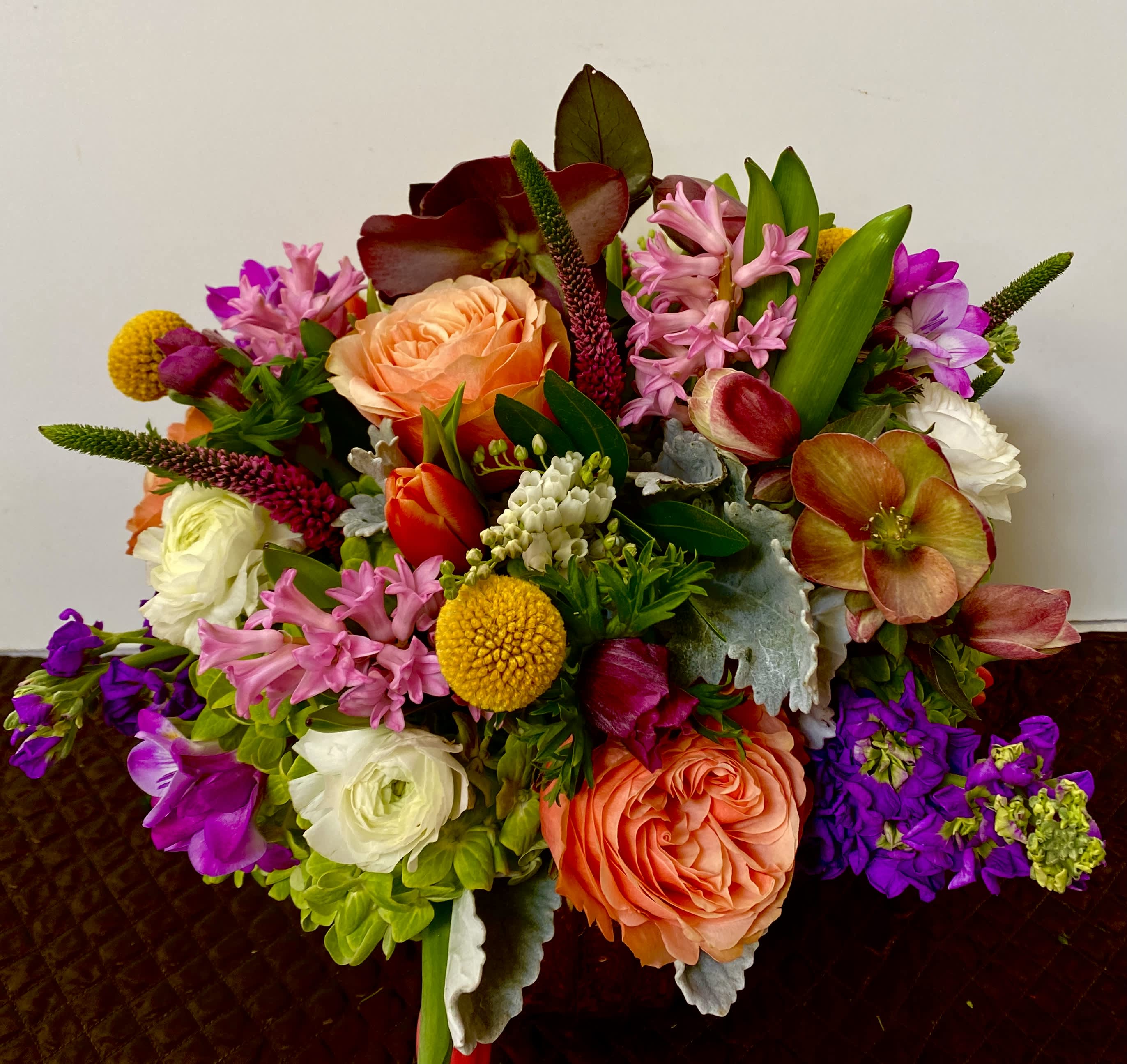 Colorful mixed bouquet with peach roses, pink blooms, and purple flowers