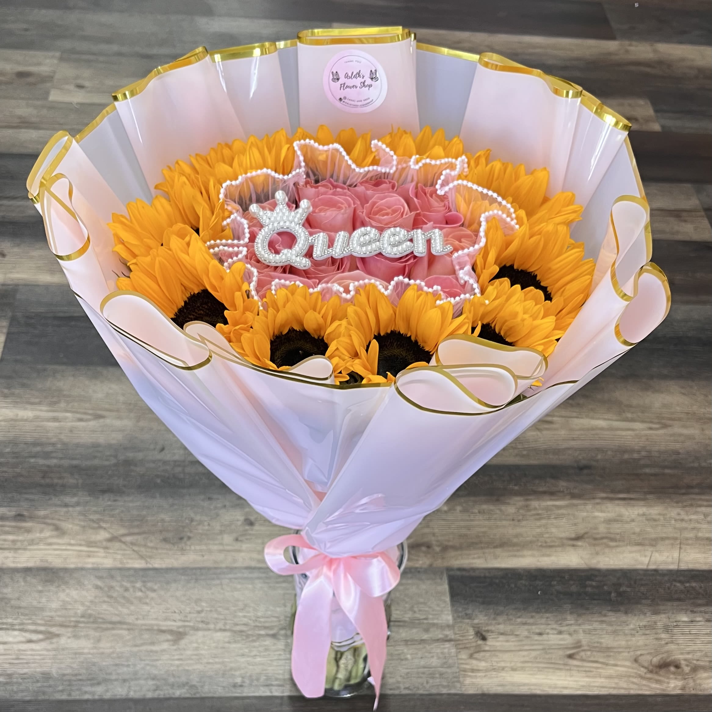 Rayito De Amor - Sunflowers And Pink Roses With Queen Topper -  A beautiful blend of sunflowers and soft pink roses, bringing warmth, love, and happiness in every detail.