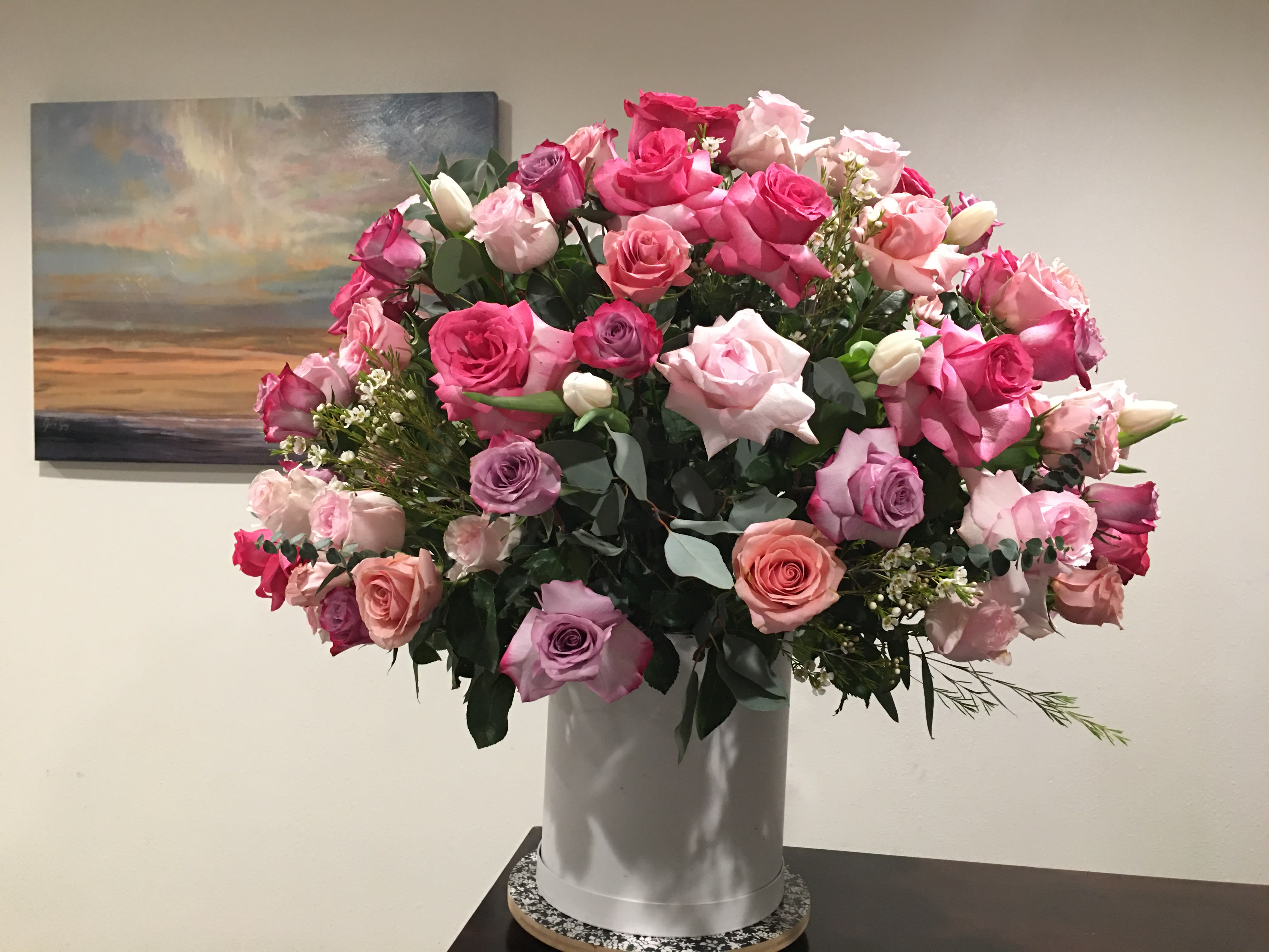 Large bouquet of pink and lavender roses in a white vase