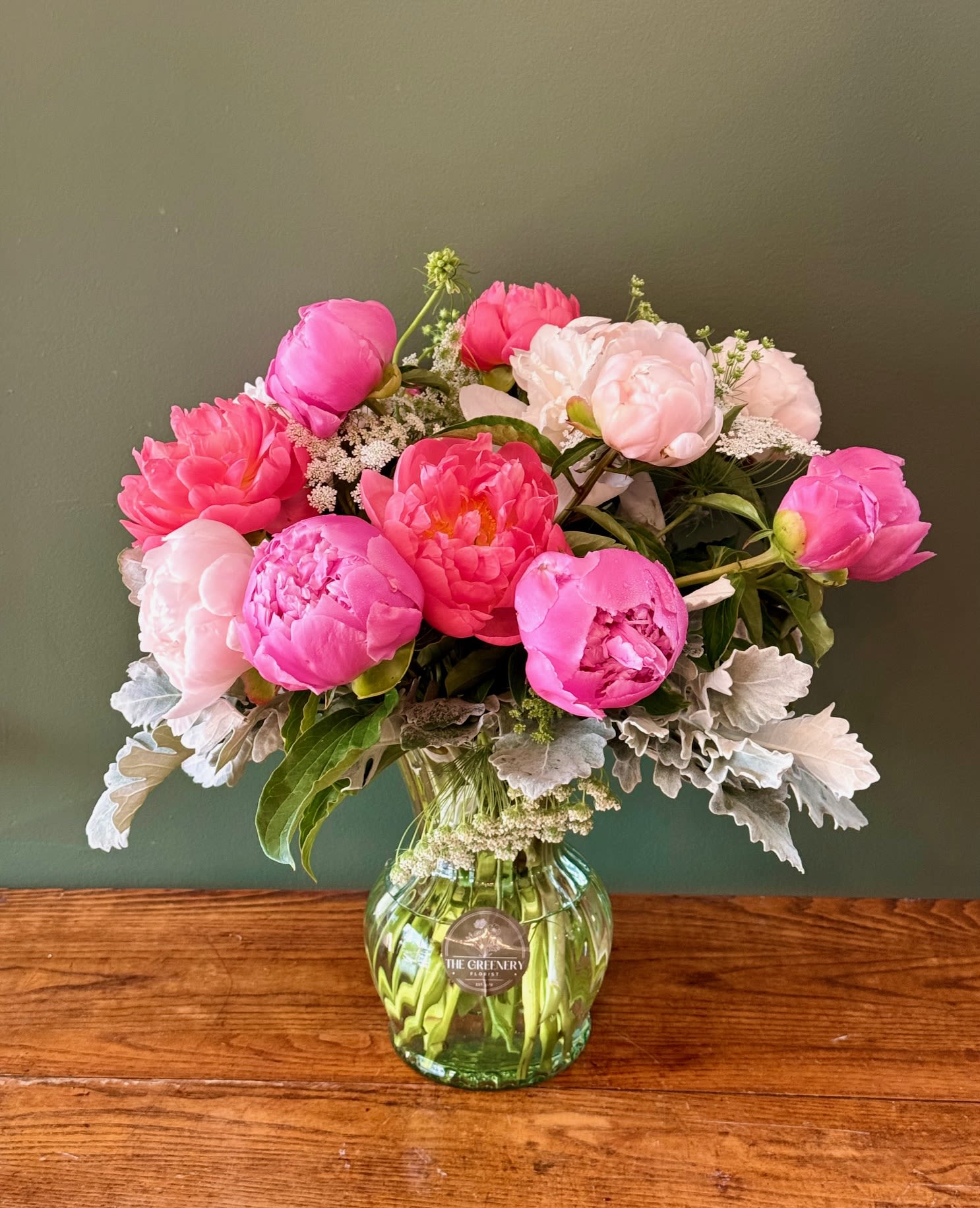 Pink and blush peonies arranged in a glass vase