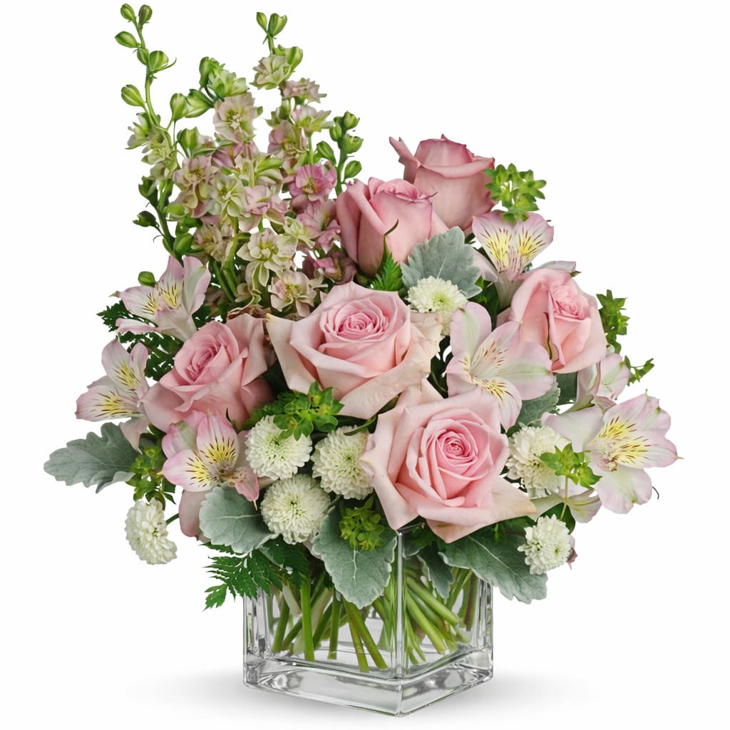 Soft Blush Garden - Delicate, romantic, and effortlessly elegant, the Soft Blush Garden arrangement features a lush gathering of premium pink roses complemented by soft accent blooms in blush, ivory, and fresh green tones. Designed in a classic clear glass cube, this arrangement highlights the natural beauty of each stem while creating a clean, modern look.  With its gentle color palette and airy garden style, this piece brings a sense of warmth and sophistication to any setting. Perfect for celebrations, heartfelt gestures, or simply adding a touch of beauty to everyday moments, this arrangement is a timeless expression of grace and charm.  Each design is handcrafted, making every arrangement uniquely beautiful. 
