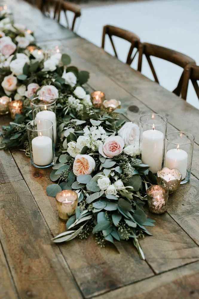 Floral table runner with white and blush blooms and glass candles