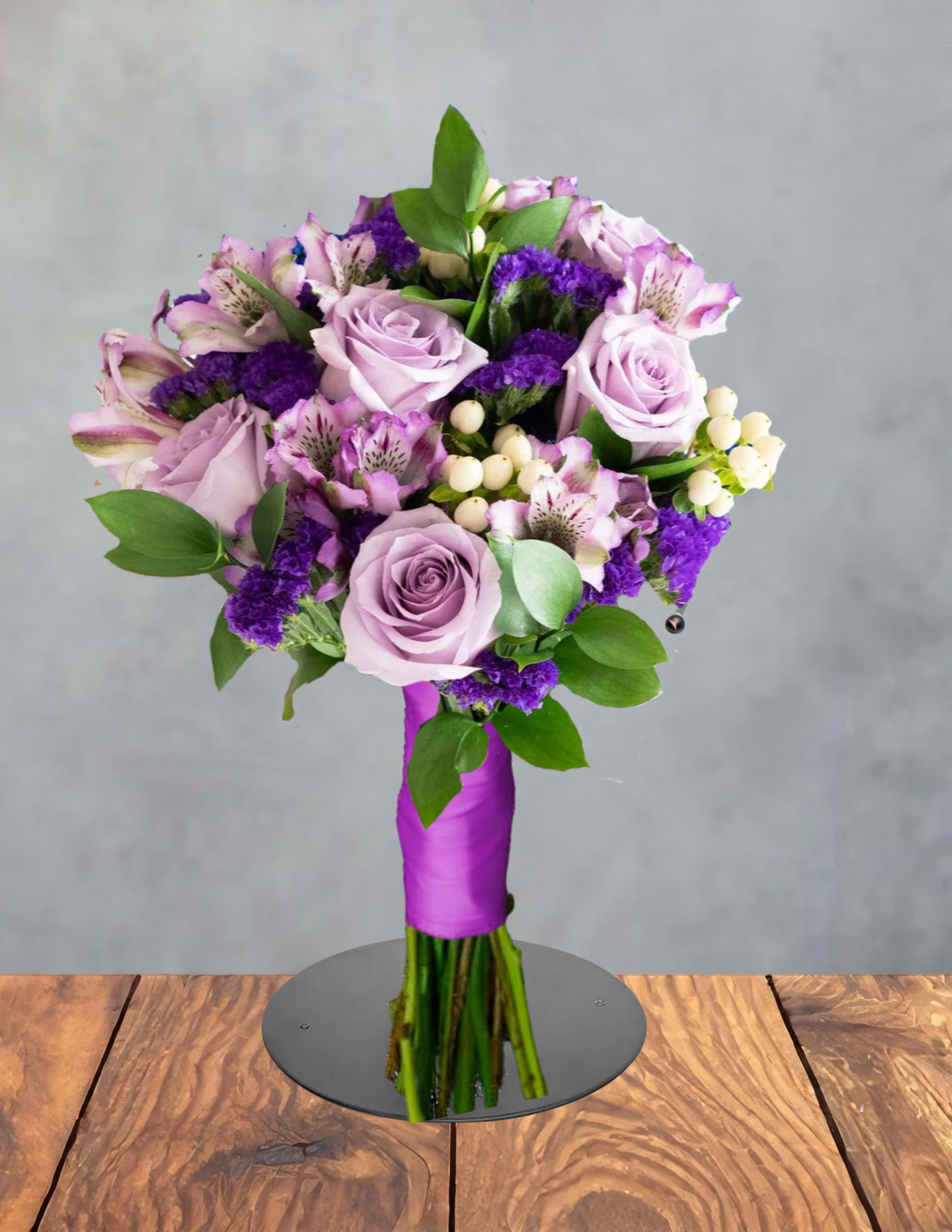 Purple prom bouquet - Lavender roses mingle with pink-and-white alstroemeria in this purple prom bouquet, a romantic hand-tied arrangement perfect for prom, anniversaries, or a special birthday. The soft pastel palette-lifted by deep purple filler blooms and bright green foliage-creates a dreamy, celebratory look that will make the person you're thinking of feel cherished and noticed.  This rounded, full bouquet also features clusters of white berries for delicate texture and contrast, with a polished purple ribbon wrap that keeps the stems neatly bound for easy carrying. Colors include purple, pink, white, and green; flowers are primarily roses and alstroemeria with complementary filler varieties and greenery to frame each bloom.  A thoughtful choice for graduation photos, a prom corsage alternative, or a surprise delivery, this bouquet arrives ready to gift and holds its shape beautifully in photos and in hand. For best results, keep blooms in fresh water and trim stems slightly before arranging in a vase.