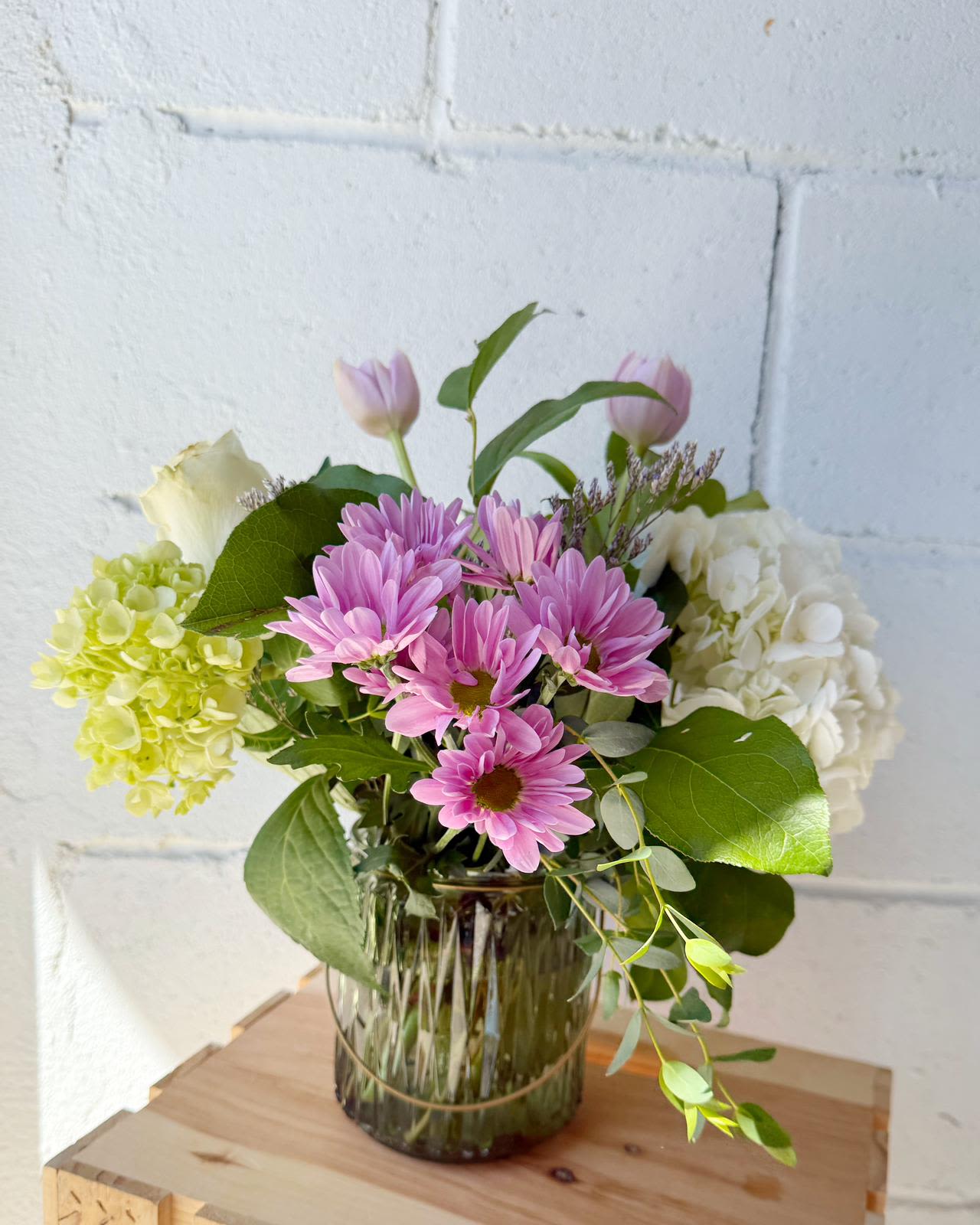 Pink daisies and hydrangeas in a glass vase