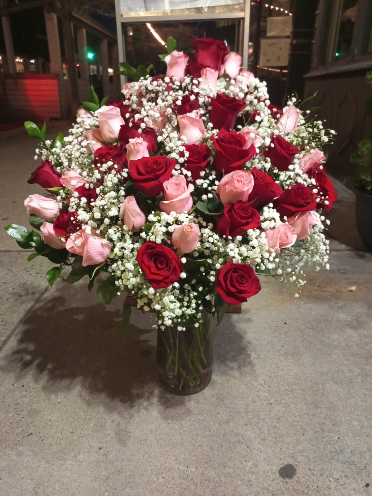 Lust for Roses - Lust for Roses – 50 Premium Roses An irresistible arrangement composed of 50 fresh roses, with 25 intense red roses that evoke passion and desire, and 25 light pink roses that add a touch of sweetness and romance.  Accompanied by delicate details of gypsophila (baby's breath) and green foliage, this design in an elegant vase creates an abundant, sophisticated, and captivating presentation.   Ideal for surprising, seducing, and expressing deep emotions on special occasions.   A detail that awakens the senses and leaves a lasting impression on the heart.