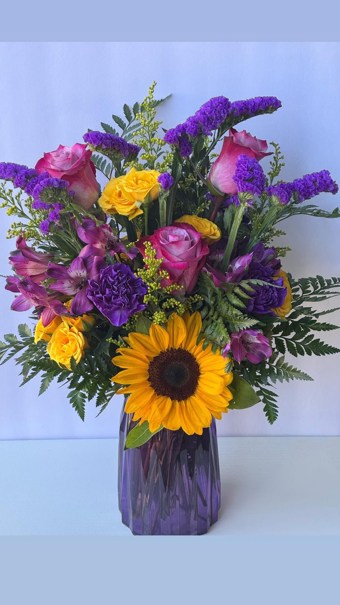Everlasting Joy - Bursting with sunshine yellows and graceful purples, this arrangement reflects the happiness bring into your lifes. Bright, loving, and unforgettable.