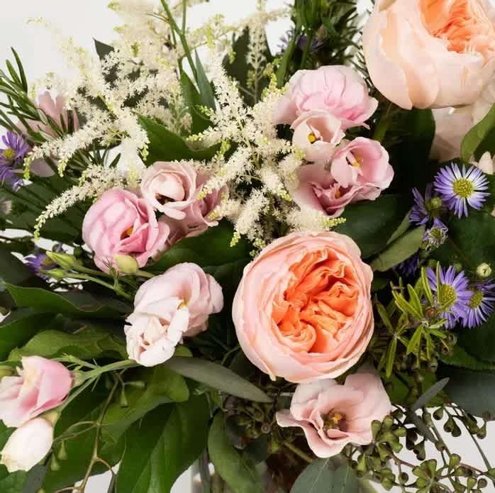 Bouquet of blush and peach flowers with purple accents