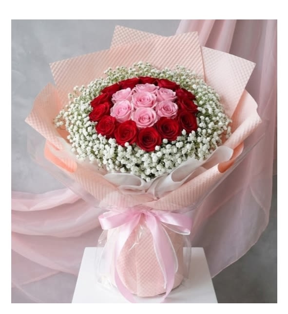 A charming Rose  wrapped Bouque  - A charming and elegant bouquet featuring 24 beautiful pink &amp; red roses gracefully accented with fresh Baby Breath fillers and wrapped in stylish pink wrapping paper. This lovely arrangement radiates warmth, admiration, and gentle affection — making it a perfect gift for birthdays, celebrations, or simply brightening someone’s day.