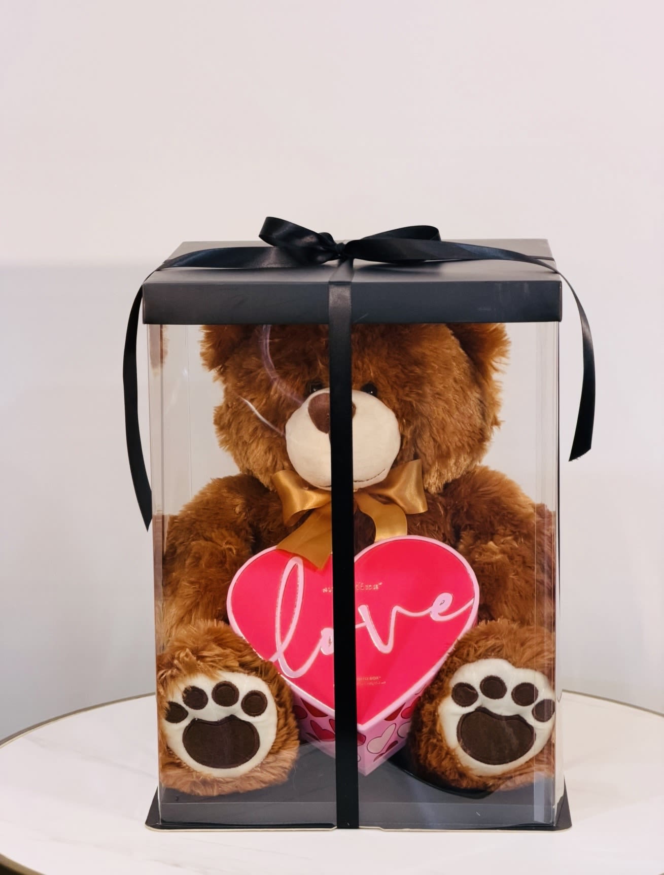 Love Teddy Bear with Heart Box &amp; Gummy Candies - Looking for a sweet and romantic gift delivered  Today ? The Love Teddy Bear Gift Box from Guy Floral Studio is the perfect way to surprise someone special. This charming gift set includes a soft, cuddly teddy bear holding a heart shaped box filled with delicious gummy candies, all beautifully arranged inside a clear gift box and finished with an elegant ribbon for a premium look. Perfect for Valentine’s Day, birthdays, anniversaries, or simply to say “I love you” in a unique and thoughtful way.  From Guy Floral Studio your boutique flower &amp; gift shop  Same day delivery available  Ready-to gift packaging  A perfect mix of softness, sweetness, and style Order now from Guy Floral Studio and make someone’s day unforgettable with a beautiful gift delivered straight to their door. 