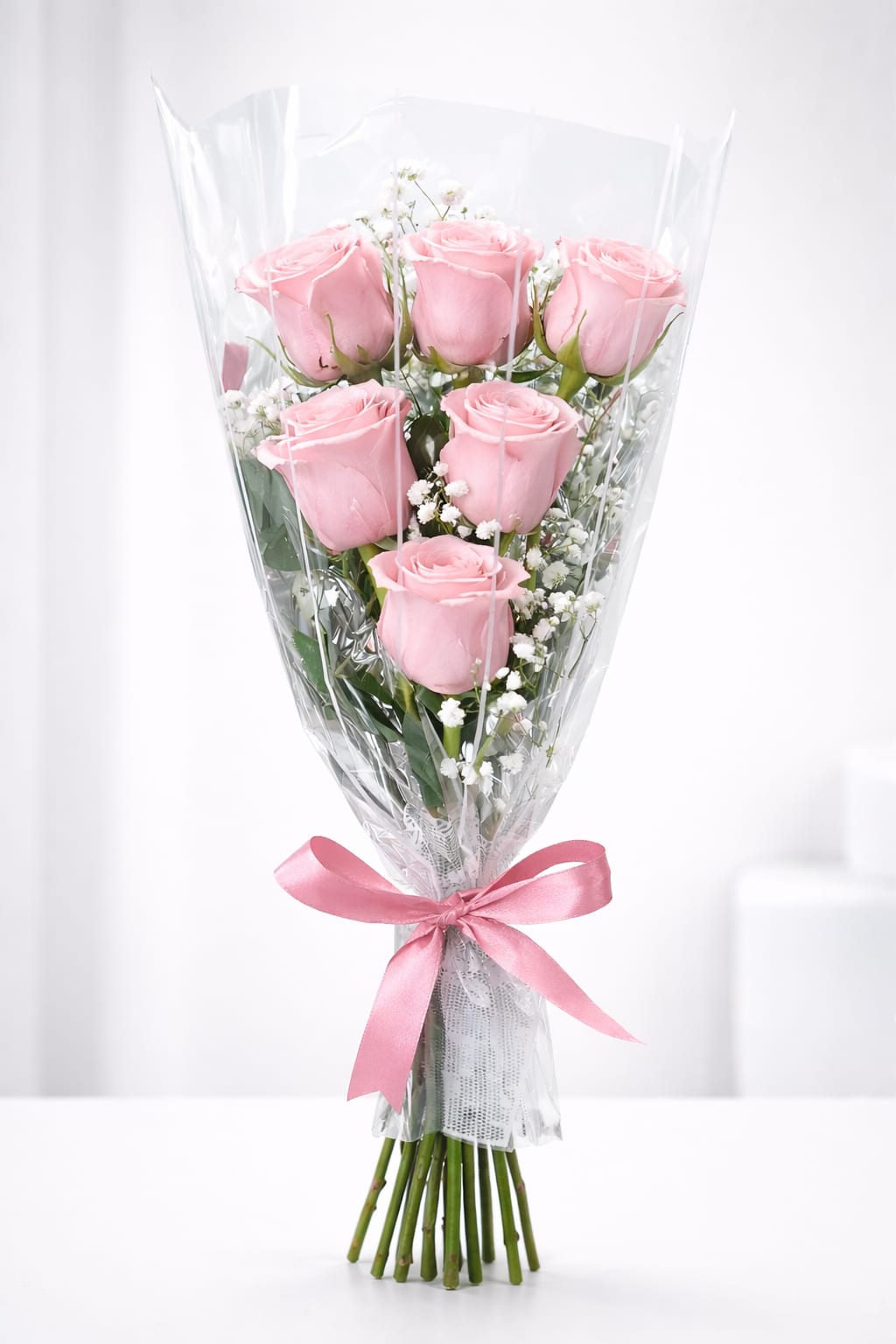 Pink rosas deluxe  - A timeless bouquet of 6 premium pink roses accented with delicate baby’s breath, wrapped in clear elegant cellophane and finished with a satin ribbon—perfect for romantic gestures, anniversaries, or simple heartfelt gifts.