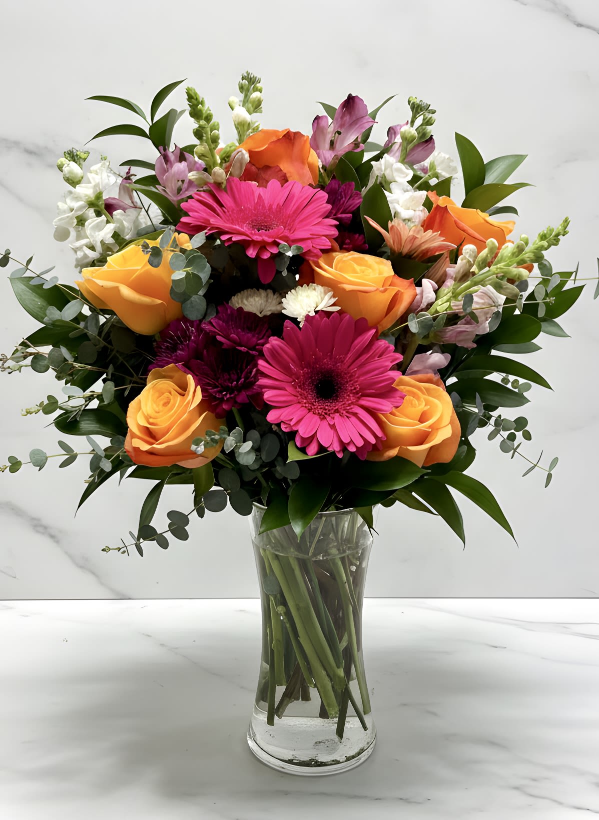 Mother Nature - Available for Mother's Day - A bright a colorful collection of spring florals with orange roses, lavender snapdragons, white stock, purple alstromeria and hot pink gerbera daisies.  