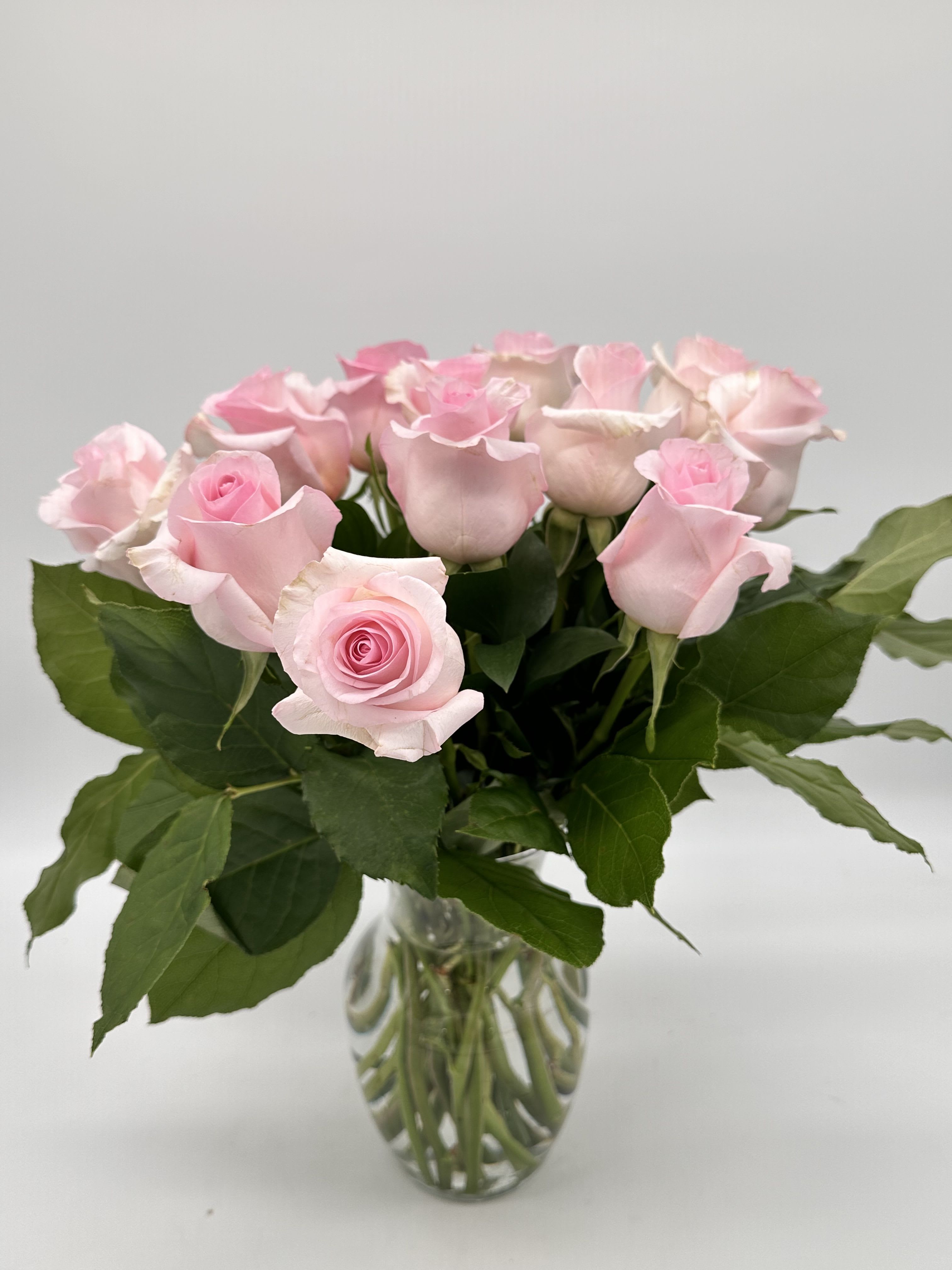 Pink roses arranged in a clear glass vase