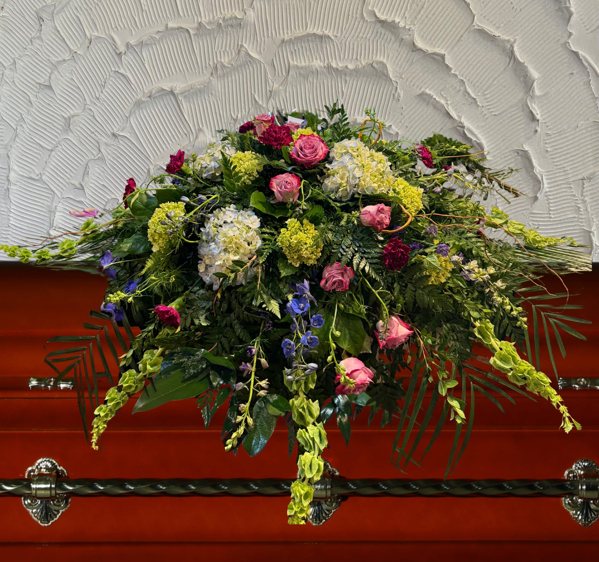 Large floral casket spray with pink roses and mixed blooms