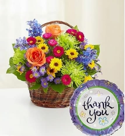 Thank You Basket - Bright orange roses and a burst of pink, yellow, purple and blue daisies spill from a woven basket in this cheerful thank-you flower arrangement - perfect as a Just Because gift or to say thanks for something special. The included round foil balloon with a grateful message lifts the mood and makes the presentation feel celebratory, so the person you're honoring will feel noticed and appreciated. 