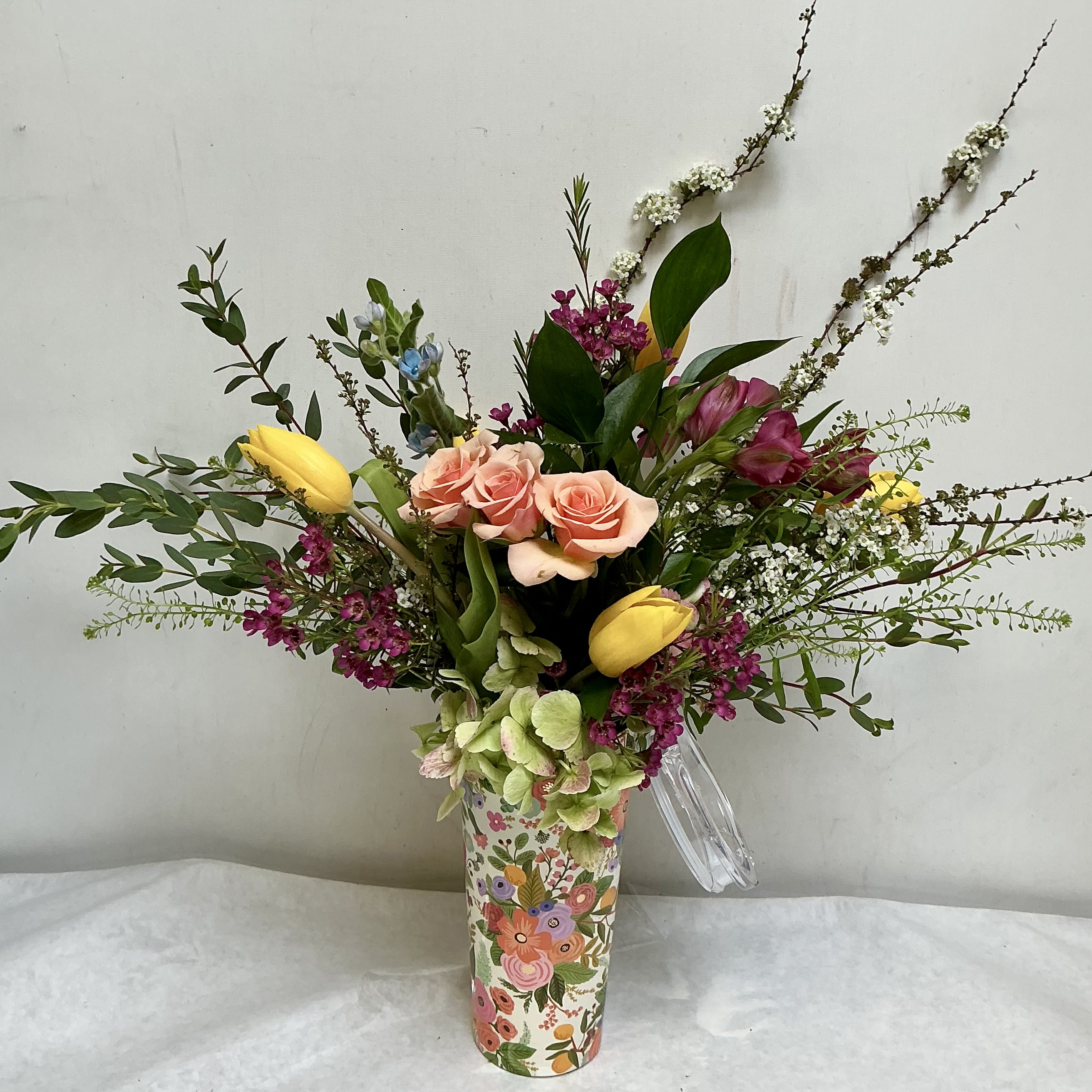 Corkcicle Garden - The mix includes roses, tulips, hydrangeas and other seasonal blooms arranged with long branching stems for a loose silhouette that looks freshly picked from a garden. Presented in a decorative floral-patterned Corkcicle travel tumbler, the arrangement arrives gift-ready-the vase adds charm and can be reused after the flowers have faded.