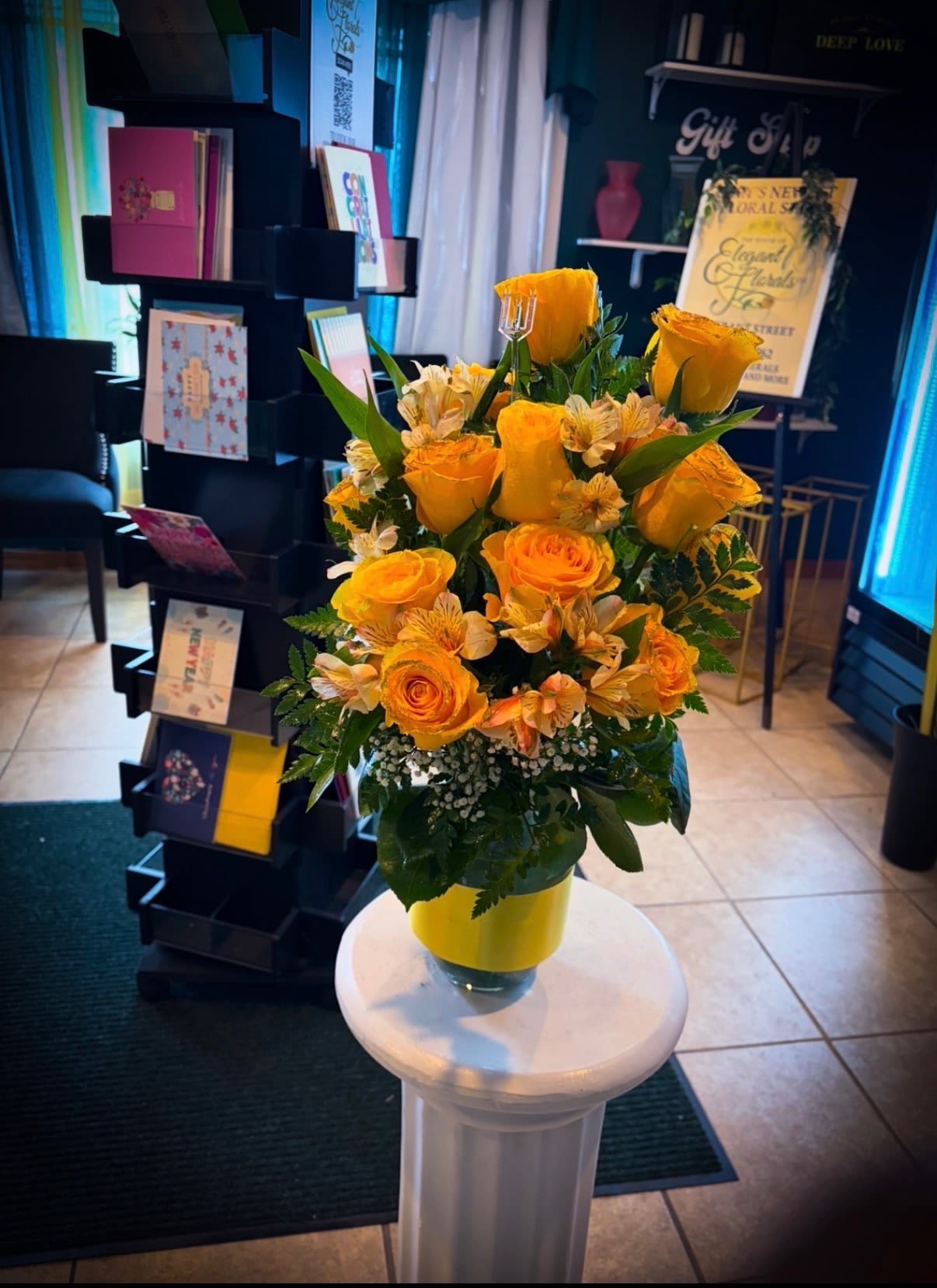 Golden Radiance - A cheerful burst of golden yellow roses paired with soft accent blooms and fresh greenery. Arranged in a bright coordinating vase, this bouquet radiates warmth and positivity—perfect for celebrations, get-well wishes, or just because.  