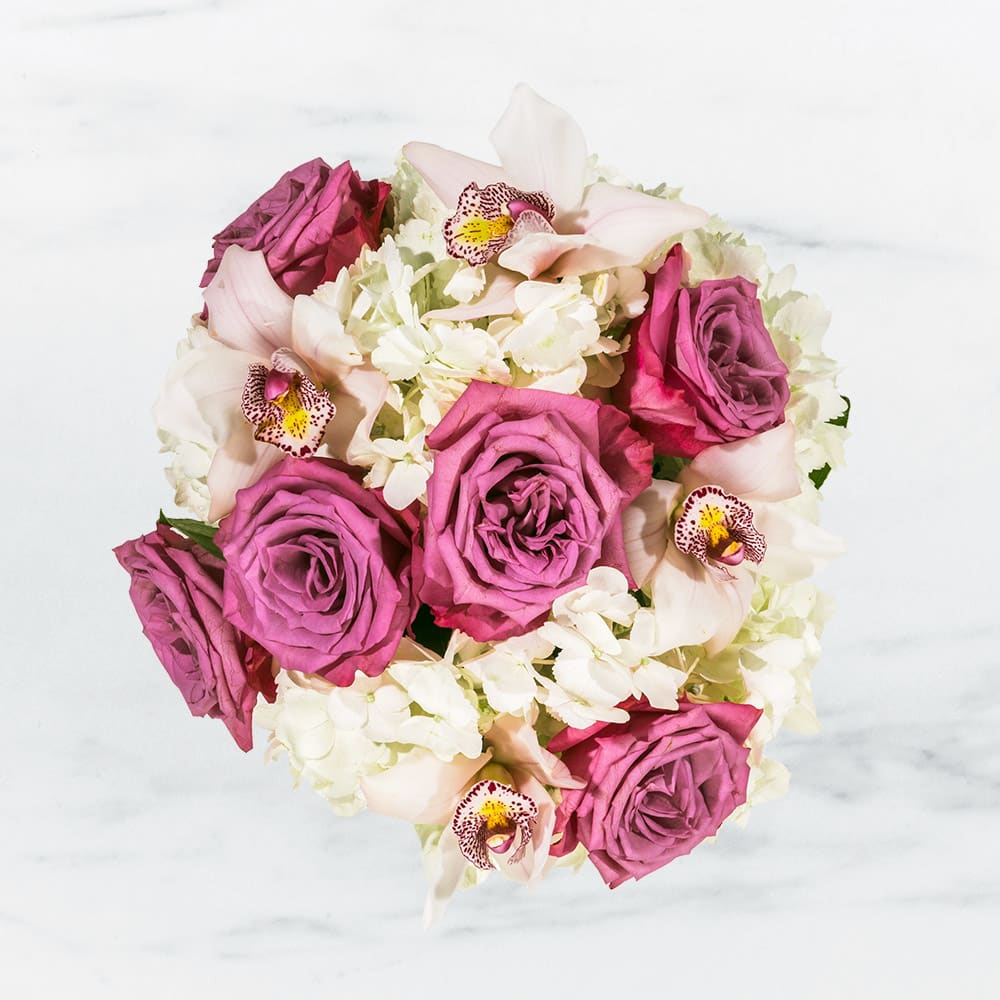 Bouquet of magenta roses, white orchids, and pale pink calla lilies