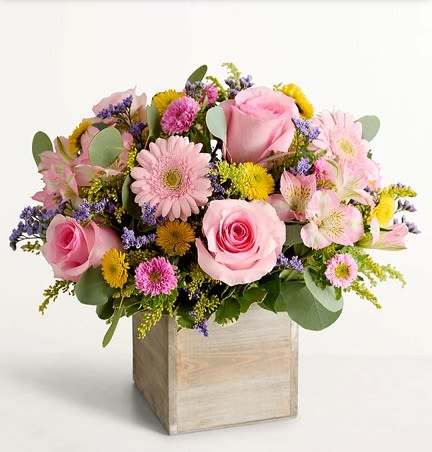 Spring Cube - Soft pink roses and pale pink gerbera daisies set the tone for this Spring Cube flower arrangement, perfect as a birthday bouquet, thank-you gift, or cheerful spring surprise. The square wooden box gives the design a rustic, hand-arranged feel that reads as both thoughtful and casually elegant-the kind of present that makes the person you're thinking of feel gently celebrated and seen